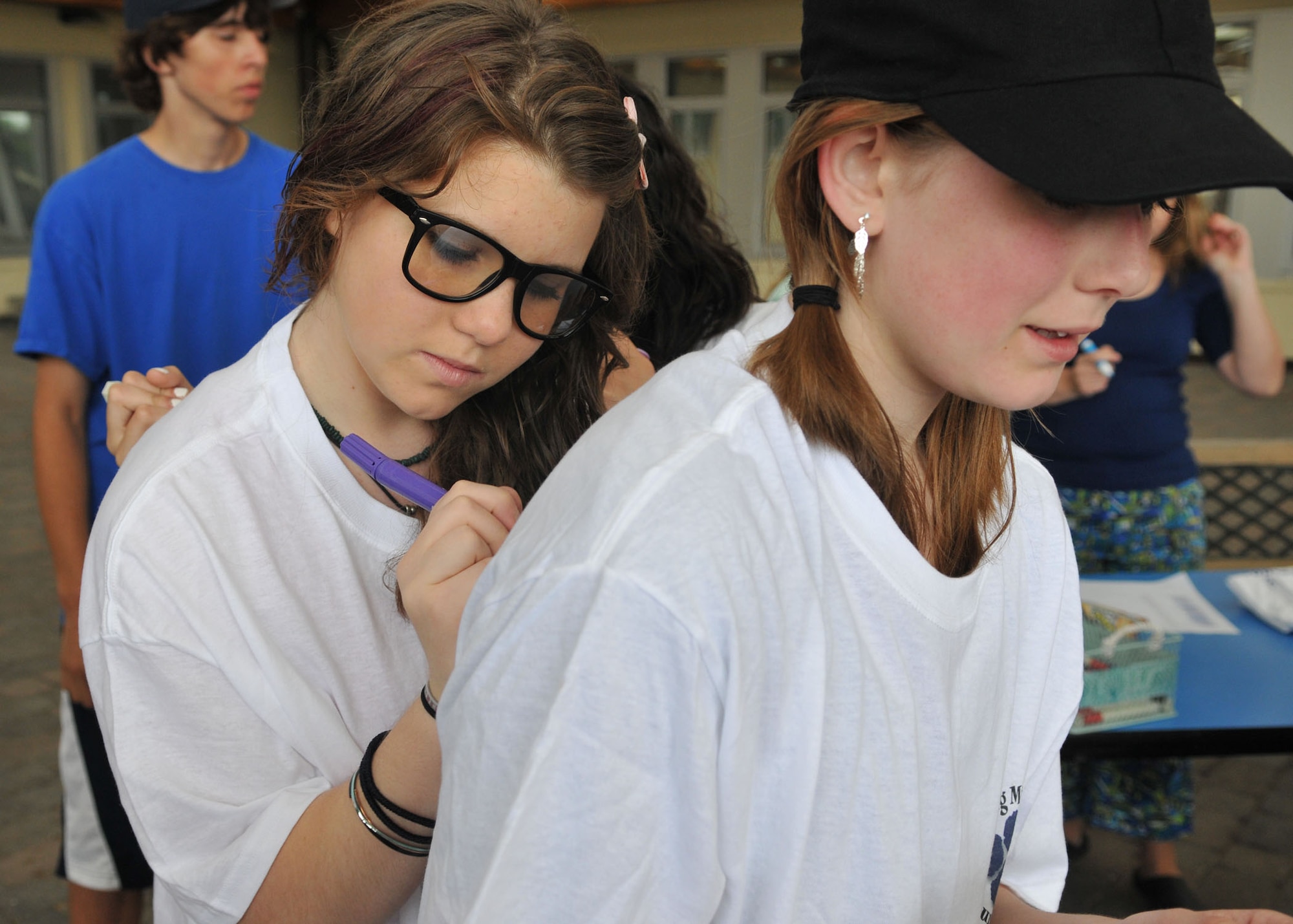 SPANGDAHLEM AIR BASE, Germany – Mary Wolfe and Nicole Boden, Bitburg Middle School eighth graders, sign each other’s T-shirts after the “Race into Summer” at Bitburg Middle School June 11. At the end of the race, the students won T-shirts and participated in a T-shirt signing event to help remember the occasion. (U.S. Air force photo by Airman 1st Class Nick Wilson)