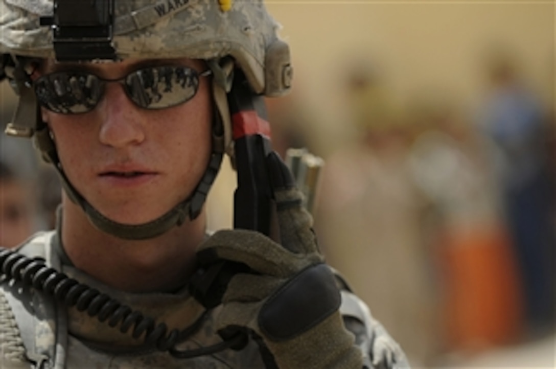 U.S. Army Pvt. Devin Ward, with Headquarters and Headquarters Company, 1st Battalion, 67th Armor Regiment, 3rd Brigade Combat Team, 1st Cavalry Division, requests additional security using his radio in the Qasr district of Mosul, Iraq, on June 10, 2009.  