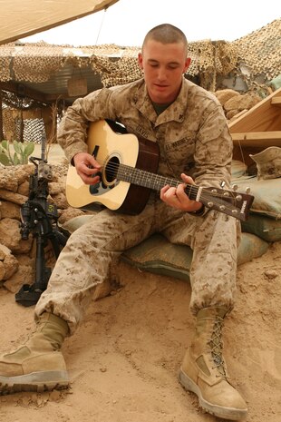 Lance Cpl. Stephen D. Davis, an infantryman with 1st Battalion, 8th Marine Regiment, plays a song he wrote, June 17, 2009, at Camp Al Taqaddum, Iraq.  Davis has been writing songs inspired by war veterans since he was 10 years old.