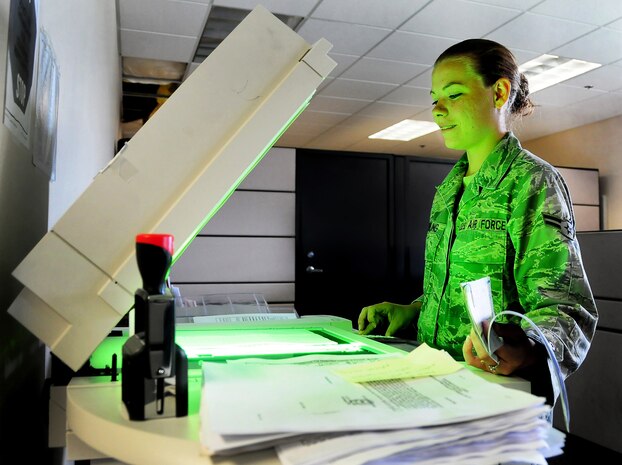 Airman 1st Class Brittney Knowling operates a copy machine at the base finance office here June 17 to create digital and paper duplicates of checks received from the base Education and Training Center. The finance office keeps accurate records of all base funds and files receipts for a period of six years and three months. Airman Knowling is a customer service technician with the 437th Comptroller Squadron. (U.S. Air Force photo/Staff Sgt. Daniel Bowles)