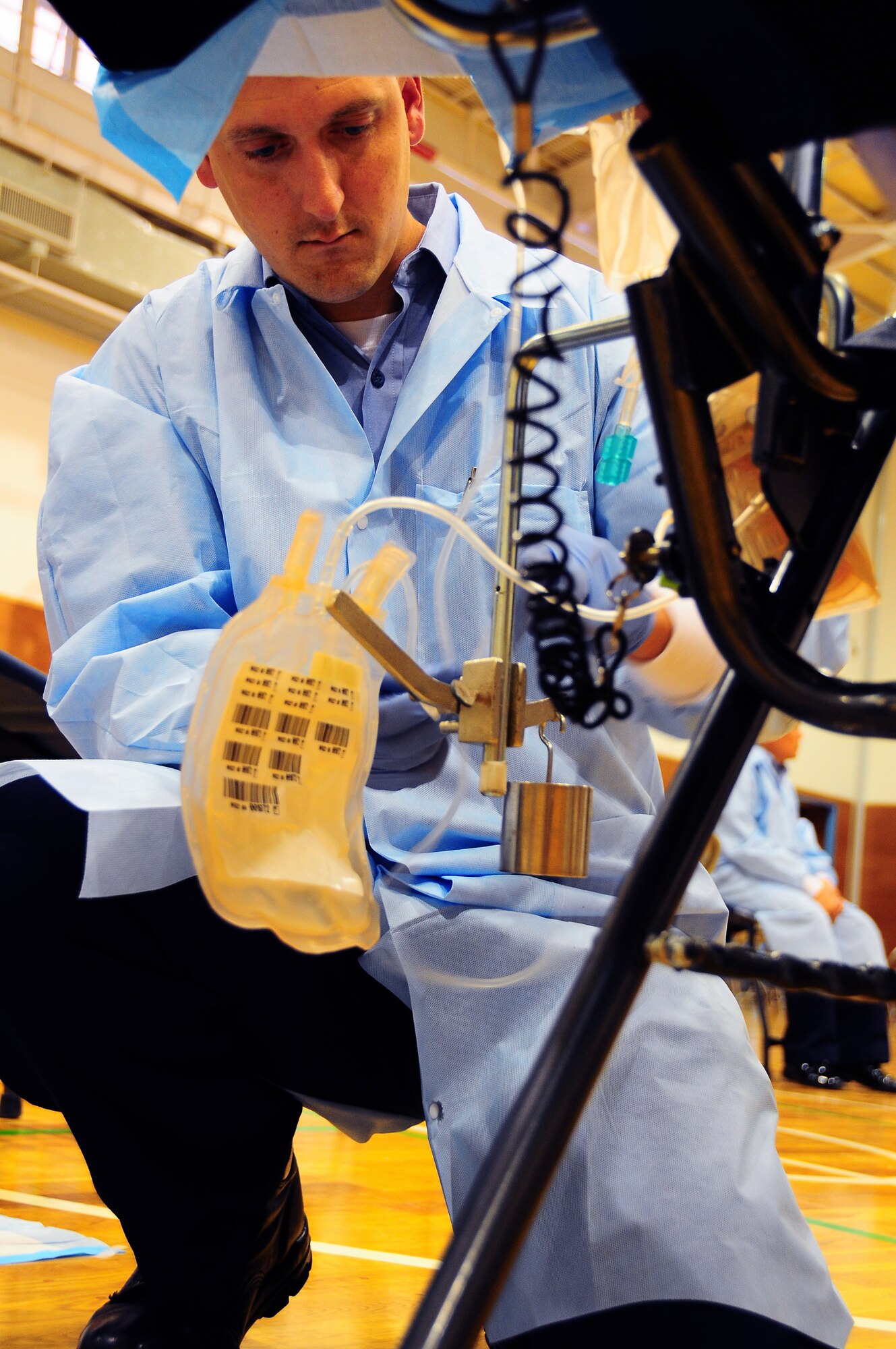 YOKOTA AIR BASE, Japan -- Petty Officer 3rd Class Michael Hart, Medical Laboratory Technician, secures the blood collection bag to a chair June 16 as part of three day Armed Services Blood Bank drive.  Petty Officer Hart is part of the team that traveled from Camp Lester in Okinawa, Japan to collect blood from the Yokota Air Base community.  (U.S. Air Force Photo/Tech. Sgt. Kimberly Spinner)