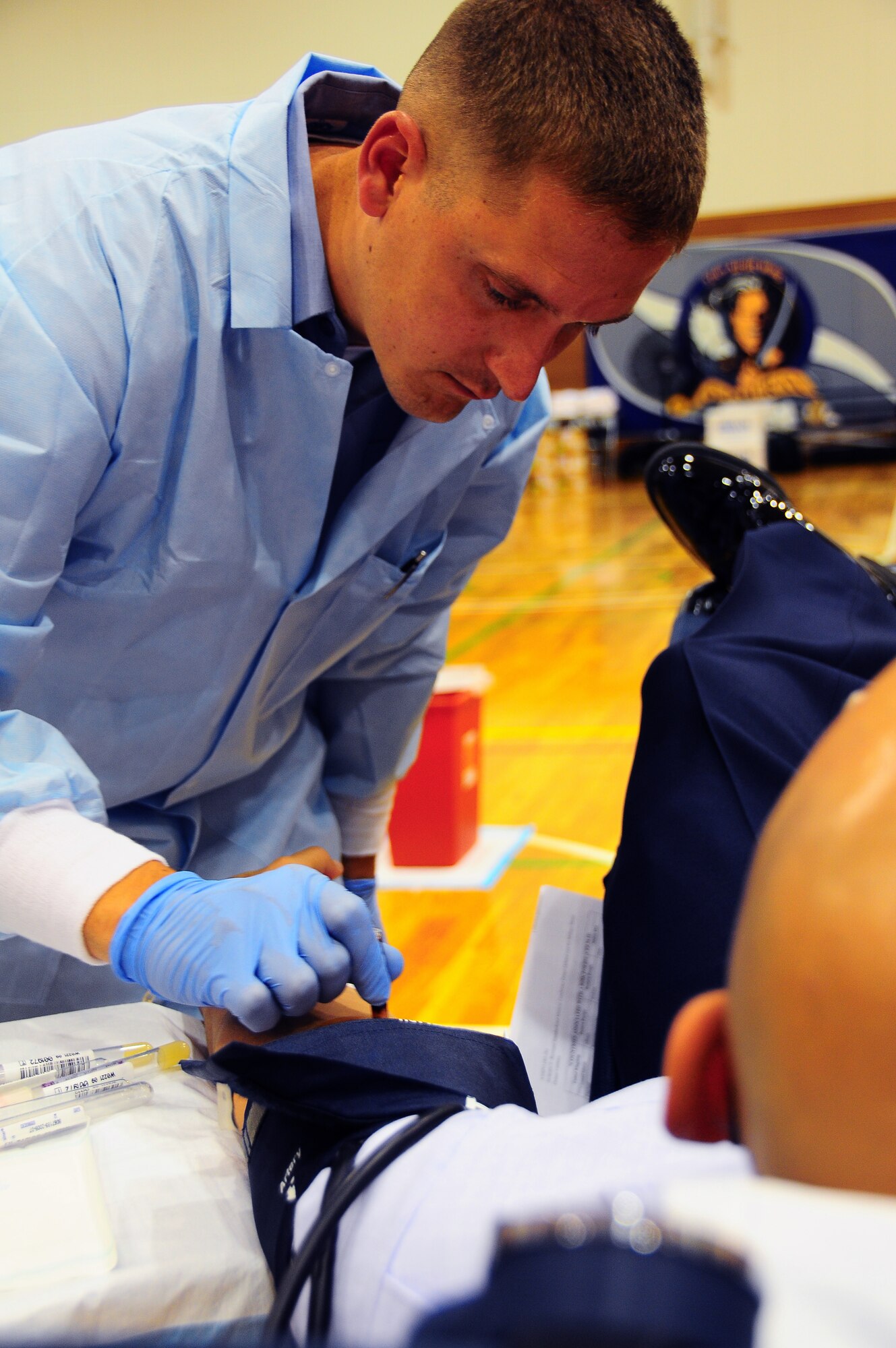 YOKOTA AIR BASE, Japan -- Petty Officer 3rd Class Michael Hart, medical laboratory technician, cleans a donors arm before drawing blood June 16 as part of three-day Armed Services Blood Bank drive.  Petty Officer Hart is part of the team that traveled from Camp Lester in Okinawa, Japan to collect blood from the Yokota Air Base community.  (U.S. Air Force Photo/Tech. Sgt. Kimberly Spinner)