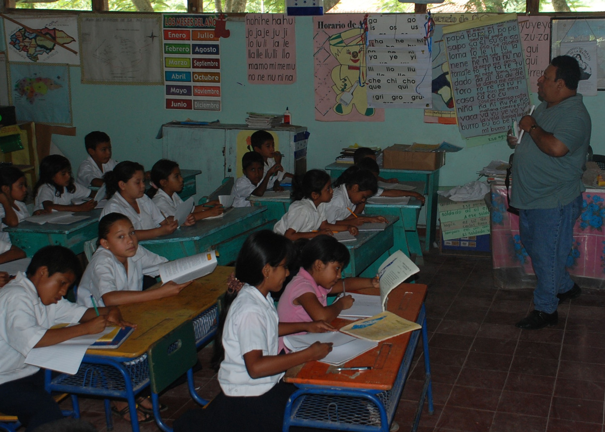 MIRA VALLE LA PAZ, Honduras - Students at Escuela Aspiracion del Valle take their lessons in near darkness because there are no lights in their classrooms.  U.S. Marine Corps civil engineers brought running water to the schoo for the first time June 16.  Crews ran water lines from a tower accross the street to the school's kitchen, bathrooms and to a drinking fountain as part of Beyond the Horizon.  BTH is a large-scale exercise taking place throughout Central America in which U.S. servicemembers complete civil engineer projects and medical readiness exercises.  (U.S. Air Force photo/Tech. Sgt. Rebecca Danét)