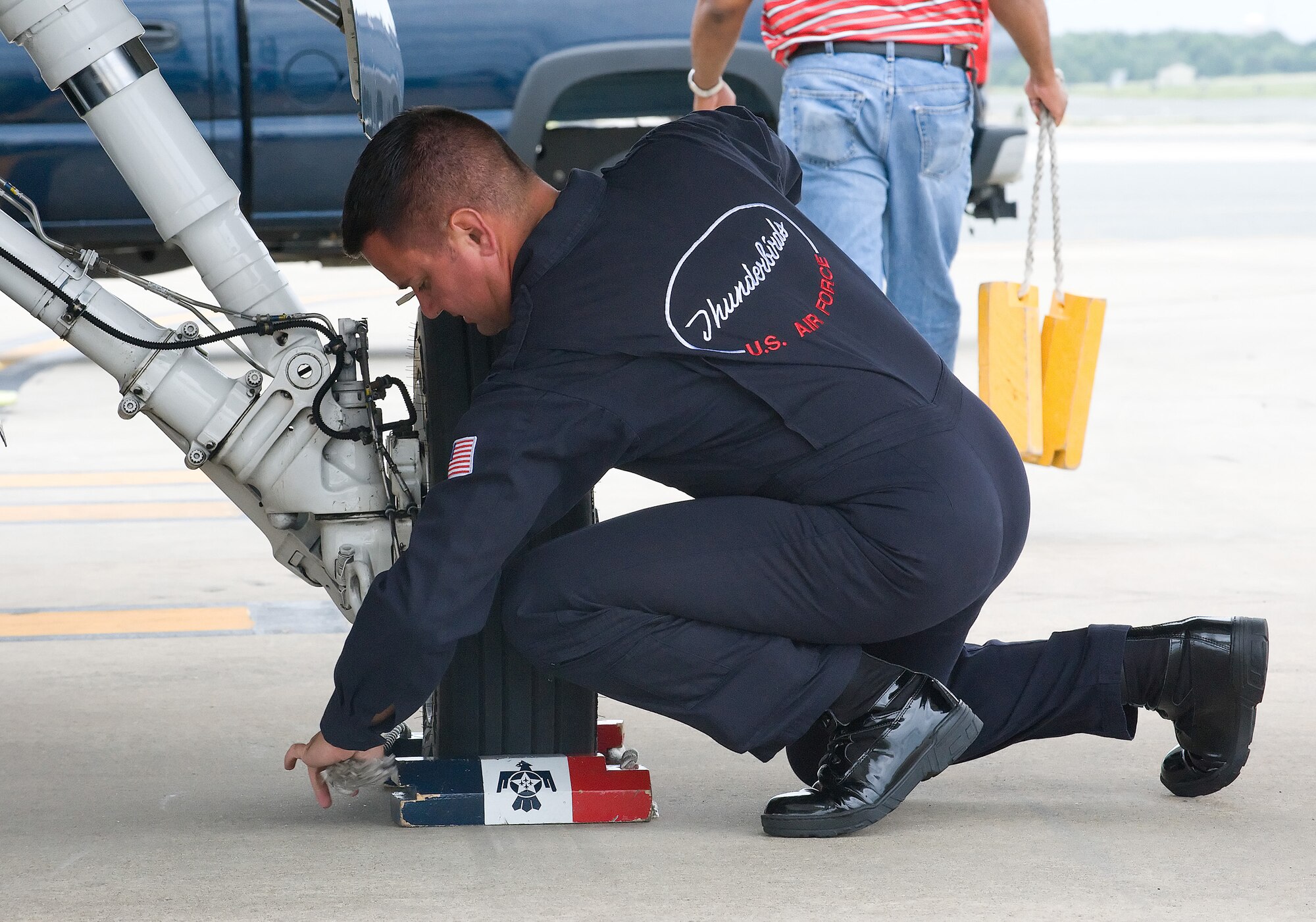 Tech. Sgt. Matthew Inman chocks Thunderbird #8 at Dover Air Force Base June 17. Maj. Tony Mulhare, Thunderbird Advance Pilot and Narrator, piloted the F-16 as the base made final preparations for the Dover Air Force Base Open House and Air Show June 20-21. (U.S. Air Force photo/Tom Randle)