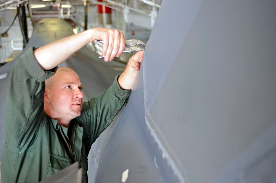Staff Sgt. Joseph Canet, 28th Maintenance Squadron crew chief, removes the saddle panel of a B-1B Lancer during an isochronal inspection here, June 16.  An average isochronal inspection is performed in 15 days and involves  inspecting and reinstalling approximately 1,000 panels. (U.S. Air Force photo/Airman 1st Class Matthew Flynn)