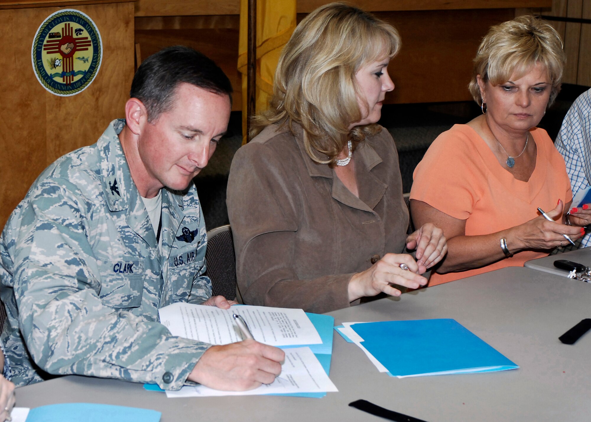 CANNON AIR FORCE BASE, N.M. -- Col. Stephen Clark, 27th Special Operations Wing commander, signs the "Keep Clovis Beautiful" resolution at Clovis City Hall on June 16. To his left are Lisa Dunagan from "Clovis Mainstreet," and Gayla Brumfield, Clovis mayor. Other  organizations that also signed the pledge are the  Curry County, Clovis/Curry County Chamber of Commerce, Clovis Community College, Clovis schools, Clovis Main Street, Clovis Industrial Development Corporation and the city itself. Cannon Airmen regularly participate in the city's biannual "Keep Clovis Beautiful" cleanup effort, to improve the community's appearance. (U.S. Air Force photo by Airman 1st Class Danielle Powell)