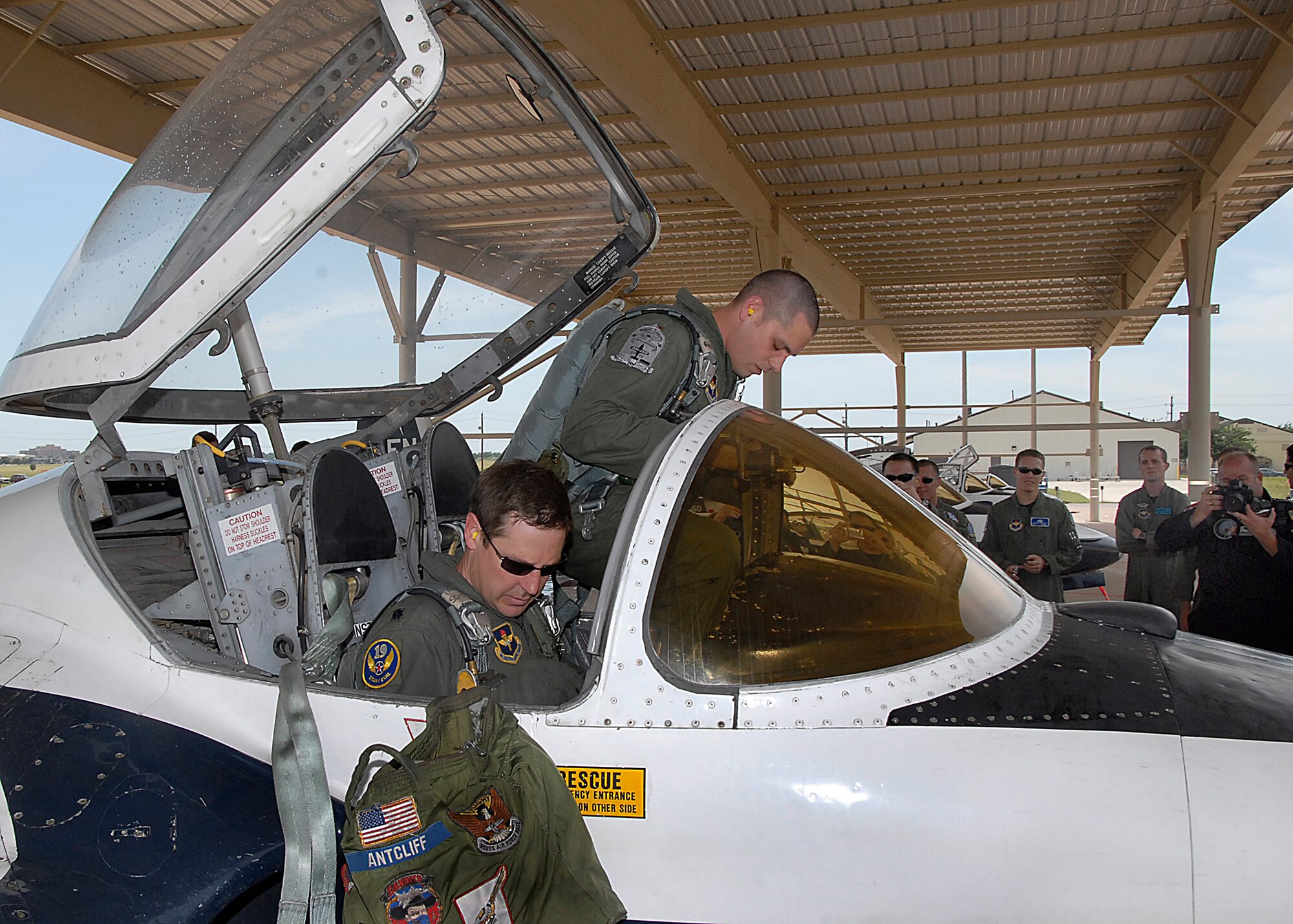 Second Lt. Trevor Kernes, standing, and Lt. Col. Doug Antcliff, 19th Air Force, prepare to egress a T-37B Tweet June 17, marking the end of the aircrafts more than 50-year service to the Air Force. More than 78,000 Air Force pilots have trained in the Tweet since 1959. (U.S. Air Force photo/Harry Tonemah)