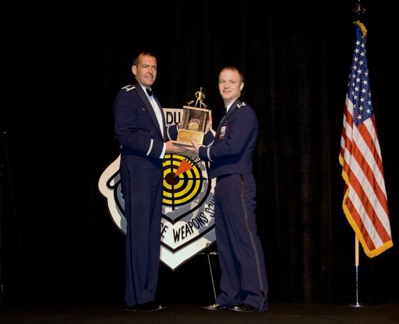 Col. Scott Kindsvater presents Capt. Christopher Stephens with one of his awards during the June 12 graduation ceremony for the Air Force Weapons School in Las Vegas, Nev. Captain Stephens was presented two awards during the graduation including an Outstanding Graduate and a Flying Award. Colonel Kindsvater is the Weapons School commandant and Captain Stephens is a pilot with the 14th Airlift Squadron. (Courtesy photo)