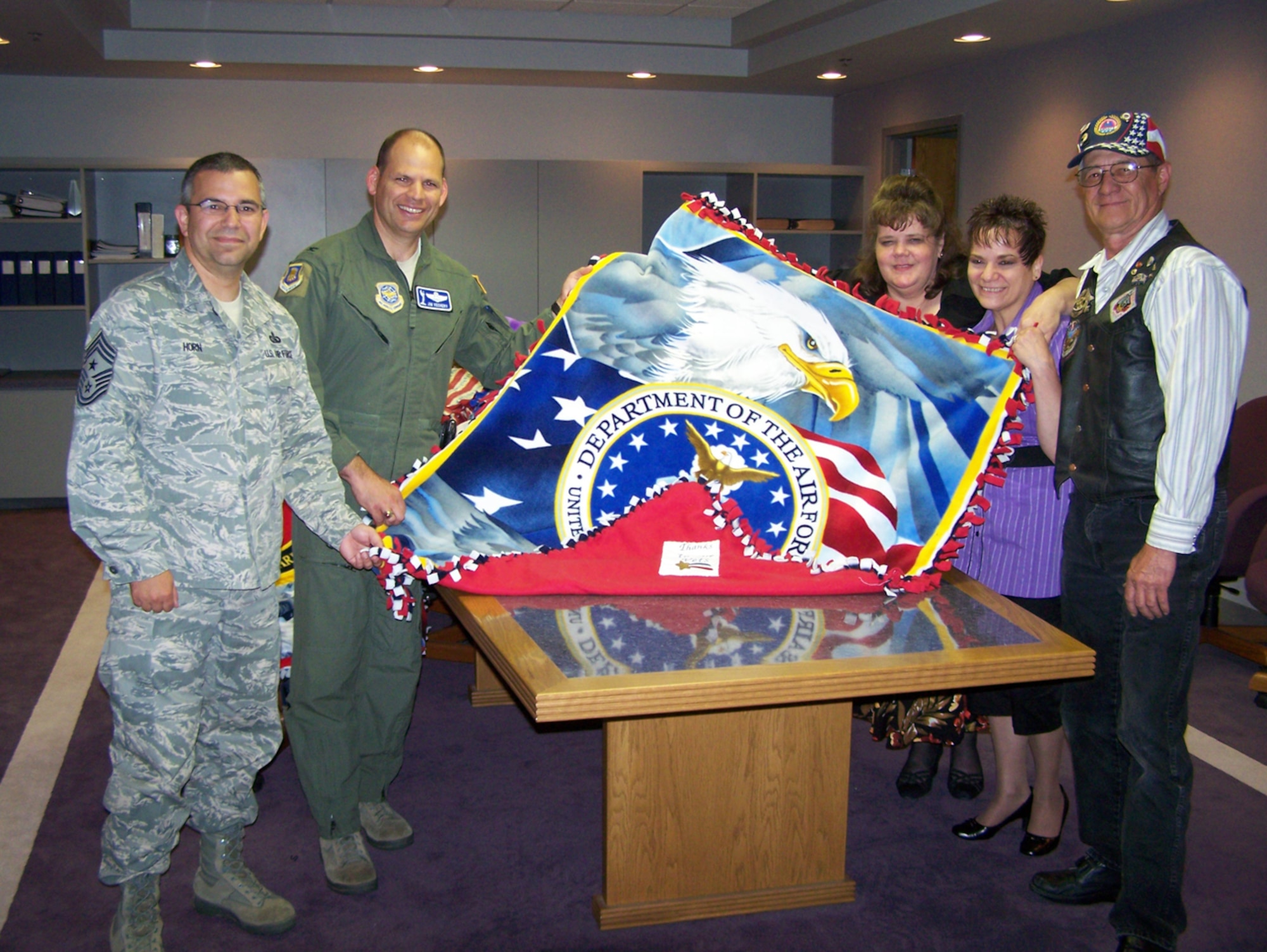 MCCONNELL AIR FORCE BASE, Kan. -- Col. James C. Vechery, 22nd Air Refueling Wing commander and Chief Master Sgt. Timothy Horn, 22nd ARW command chief, preside as Judy Strobbe and Camille Walker from Freedom 1st Federal Credit Union, present a hand-tied blanket to the outgoing commander of the AMVETS Larry Shippey, June 11.  Forty blankets along with other items were made and donated by the employees of the credit union and taken to the Fort Dodge Soldiers Home outside of Dodge City, Kan.,  June 13. (Courtesy photo)