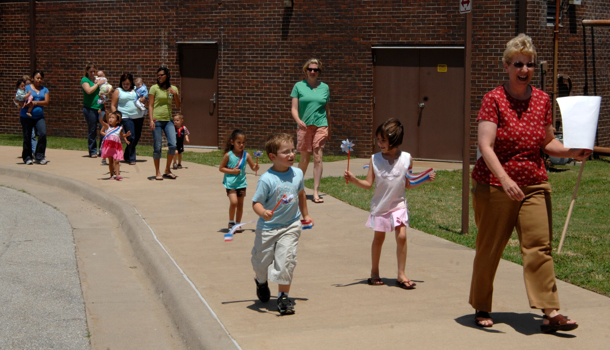 MCCONNELL AIR FORCE BASE, Kan. -- The McConnell children’s playgroup walks in a parade to celebrate Flag Day at McConnell AFB, June 16. Mothers and teachers joined in the celebratory walk for Flag Day, while the children carried patriotic pinwheels and streamers. (Photo by Senior Airman Laura Suttles)