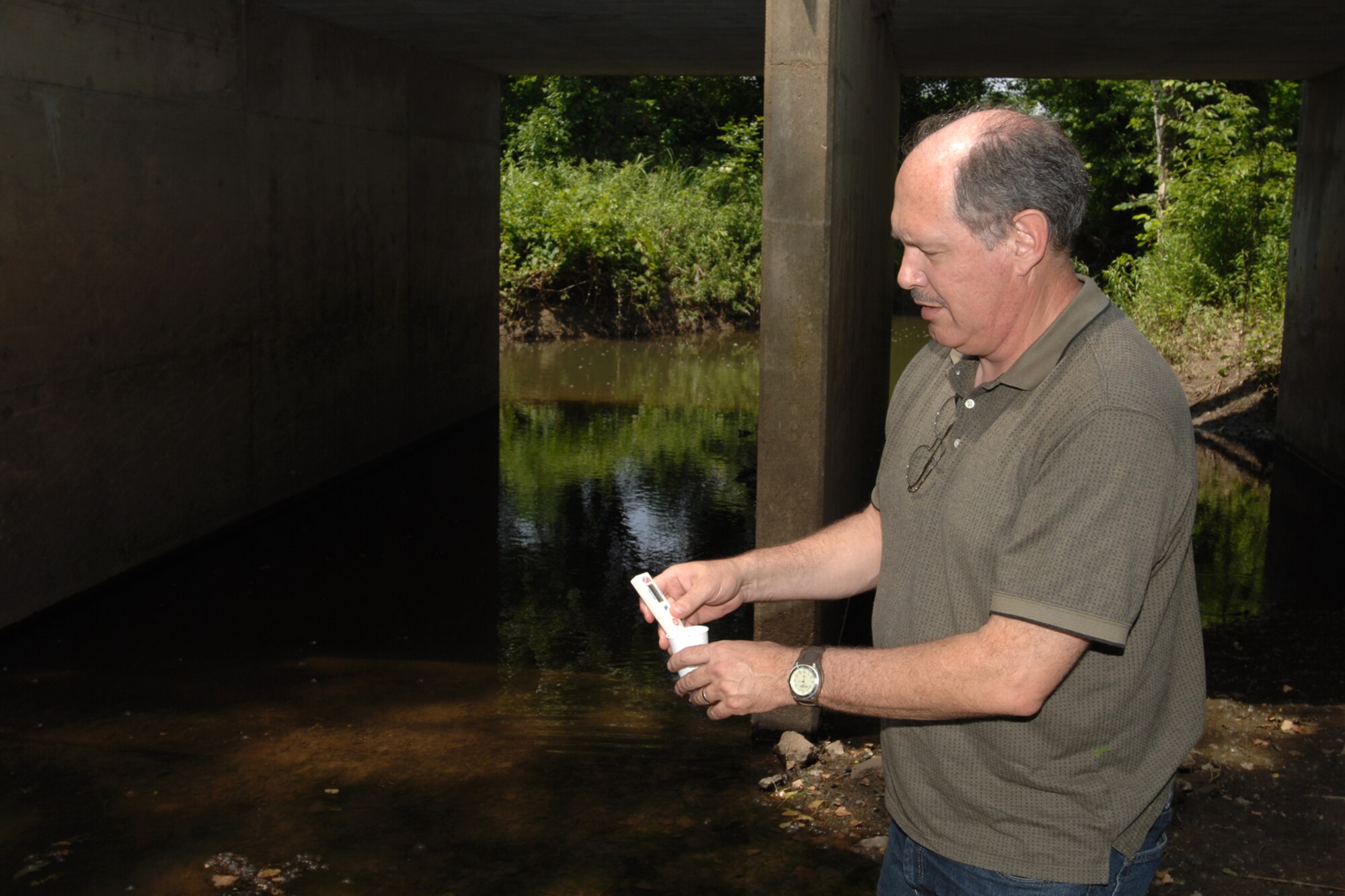 MCCONNELL AIR FORCE BASE, Kan. -- David Pettus, 22nd Civil Engineer Squadron environmental engineer, checks the pH balance of a creek before it leaves base property, June 15. Mr. Pettus is in charge of the water management on base to include storm, waste, and drinking water. (Photo by Staff Sgt. Jamie Train)
 
