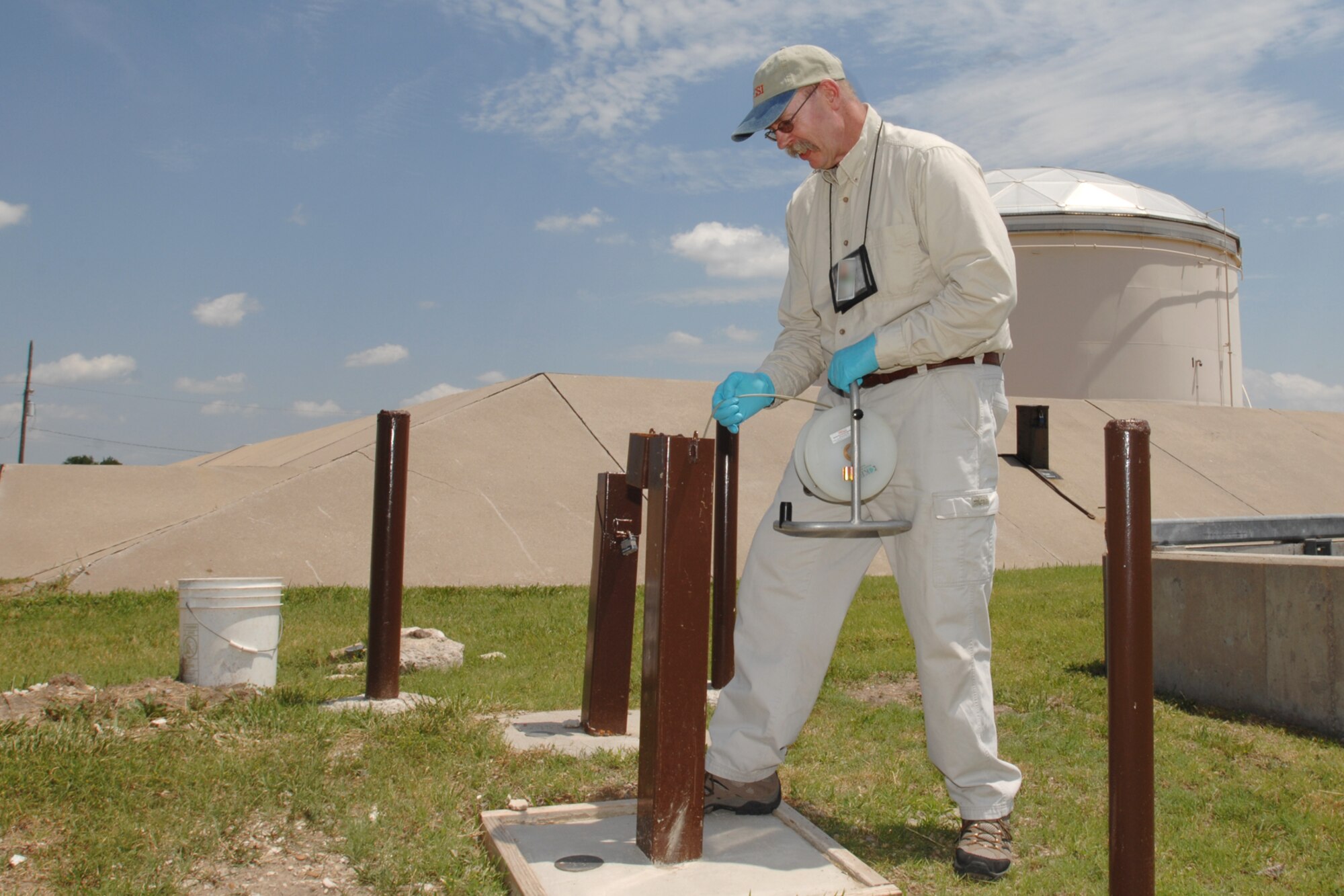 MCCONNELL AIR FORCE BASE, Kan. -- Dennis Heyer, 22nd Civil Engineer Squadron environmental contractor, checks the water flow using a water level meter at a monitoring well, June 15. The meter provides data telling which way water is flowing and water volume. (Photo by Staff Sgt. Jamie Train)
 
