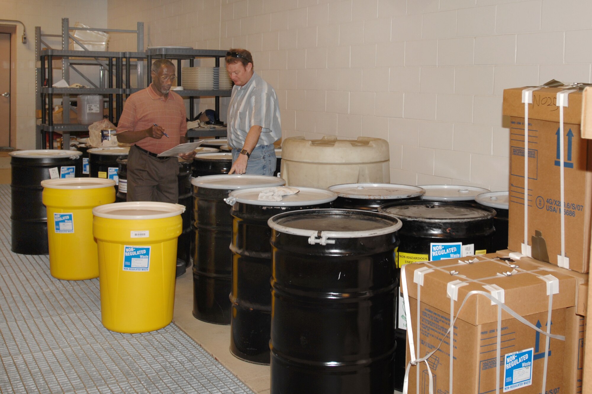 MCCONNELL AIR FORCE BASE, Kan. -- Al Wright and Pat O’Brien, both 22nd Civil Engineer Squadron environmental flight, conduct an inventory of non-resource conservation recovery act items at the 90 day storage facility, June 15. Non-RCRA items include batteries, lamps, and mats to clean up spills that occur on base. (Photo by Staff Sgt. Jamie Train)
 
