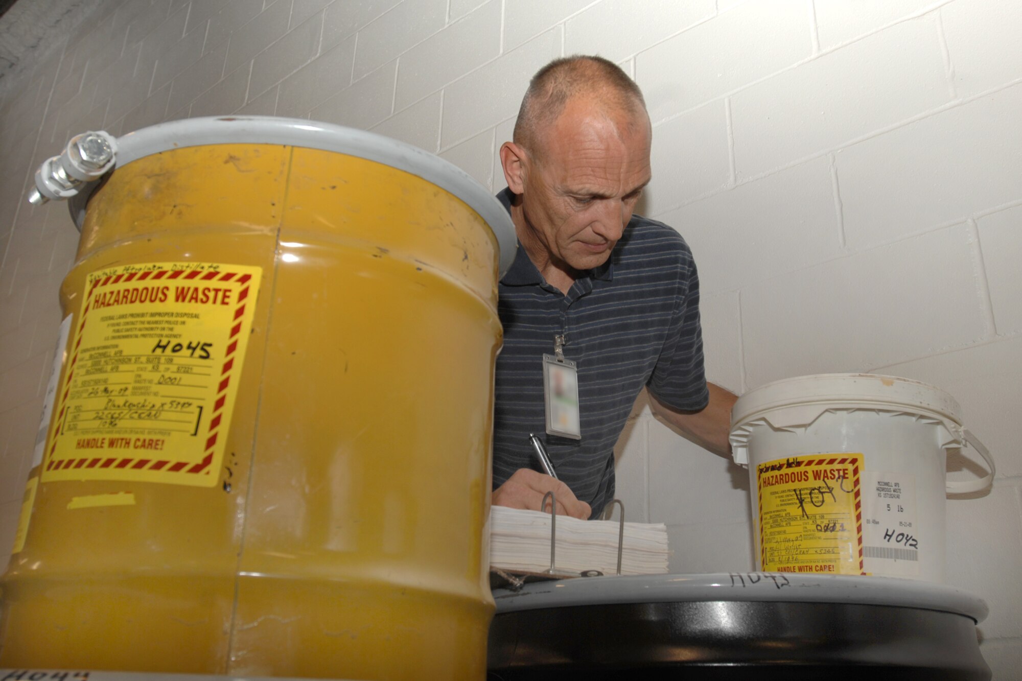 MCCONNELL AIR FORCE BASE, Kan. -- Miles Blankenship, 22nd Civil Engineer Squadron environmental chemist, inspects hazardous waste at the 90 day storage facility, June 15. The hazardous wastes that are properly turned in include items such as solvents, paints, adhesives, fuels, and heavy metals. (Photo by Staff Sgt. Jamie Train)
 
