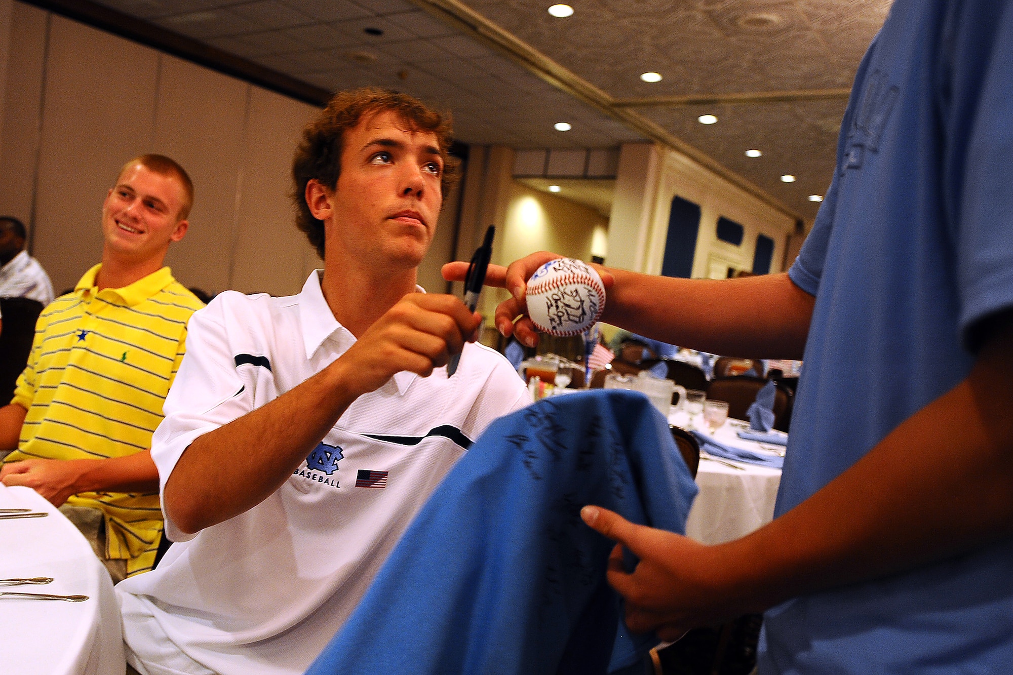 OFFUTT AIR FORCE BASE Neb.,-- Catcher Jacob Stallings, with the University of North Carolina Baseball Team, signs autographs during a luncheon at the Patriot Club as part of a base tour where members of the Tar heels got an inside look at the mission of the 55th Wing, 15 June.  The Tar Heels baseball team is competing in the NCAA College World Series hosted at Omaha's Rosenblatt Stadium June 13-23/24.

U.S. Air Force Photo by Josh Plueger
