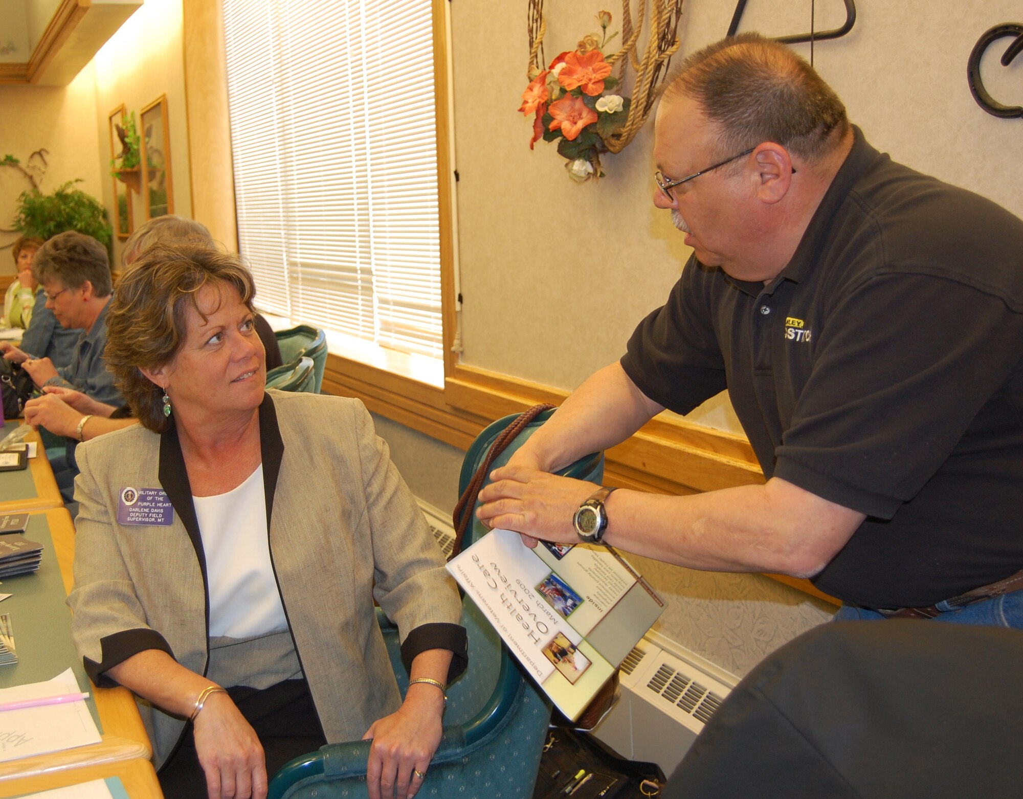 Darlene Davis, the deputy field supervisor for the Military Order of the Purple Heart organization, chats with retired Chief Master Sgt. Mike DeRosa May. 14. In her current position, Ms. Davis is an advocate for veterans issues and concerns with the VA. She was attending the monthly meeting of the Montana Retiree's Council at the Elkhorn Diner to spread the word about her services. (U.S. Air Force photo/Valerie Mullett)