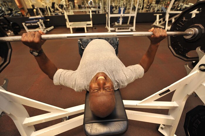 Capt. Jacqueline Young bench presses during his physical training routine June 16. As of January 2010, the Air Force will implement changes to its fitness program, increasing how many times a year Airmen are tested and simplifying age range requirements into five categories. Captain Young is the acting commander of the 437th Communications Squadron. (U.S. Air Force photo/James M. Bowman)