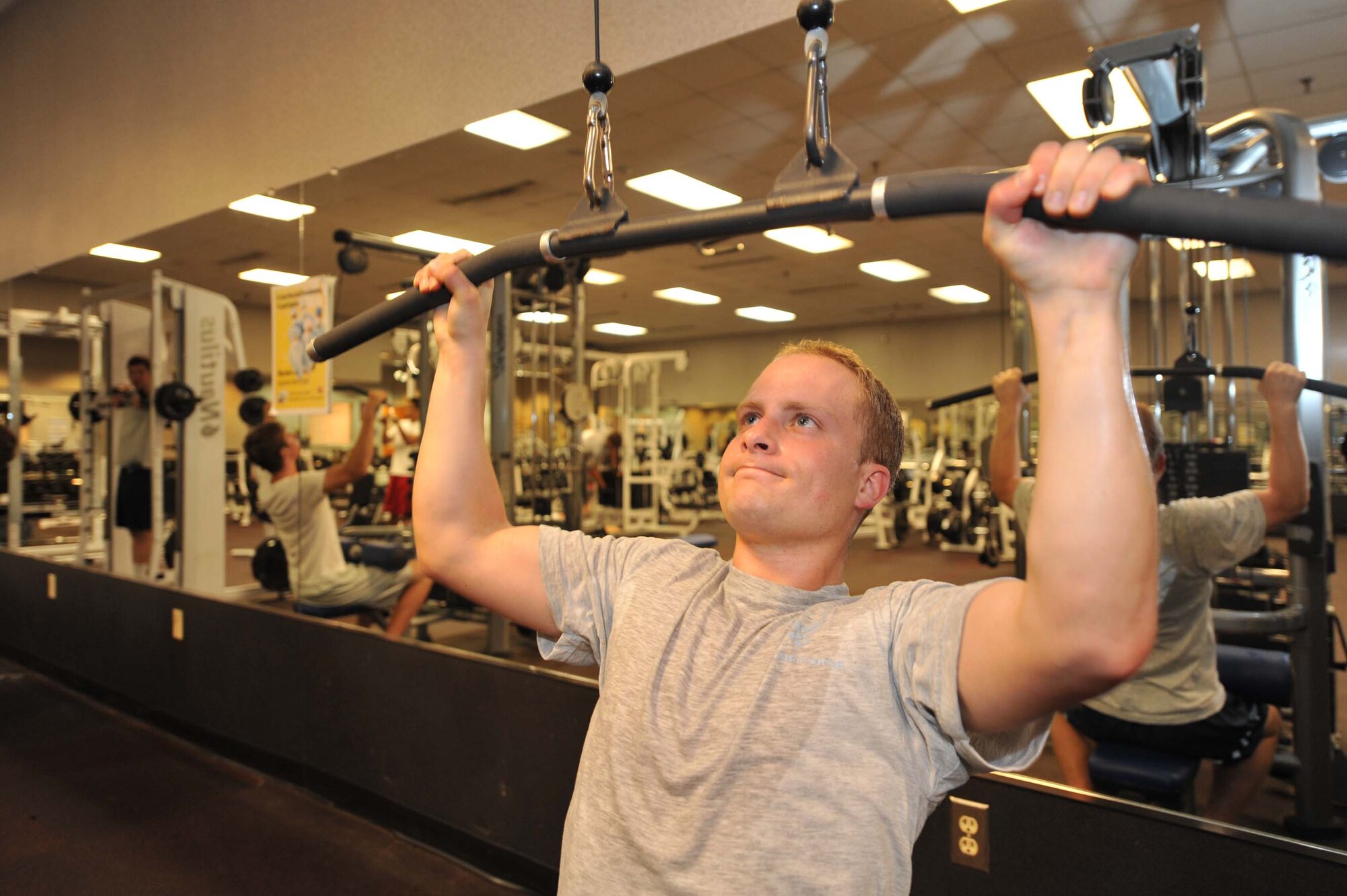 First Lt. Danny Graham works outs during physical training at the base gym June 16. As of January 2010, the Air Force will implement changes to its fitness program, increasing how many times a year Airmen are tested and simplifying age range requirements into five categories. Lieutenant Graham is an executive officer with the 437th Mission Support Group. (U.S. Air Force photo/James M. Bowman)