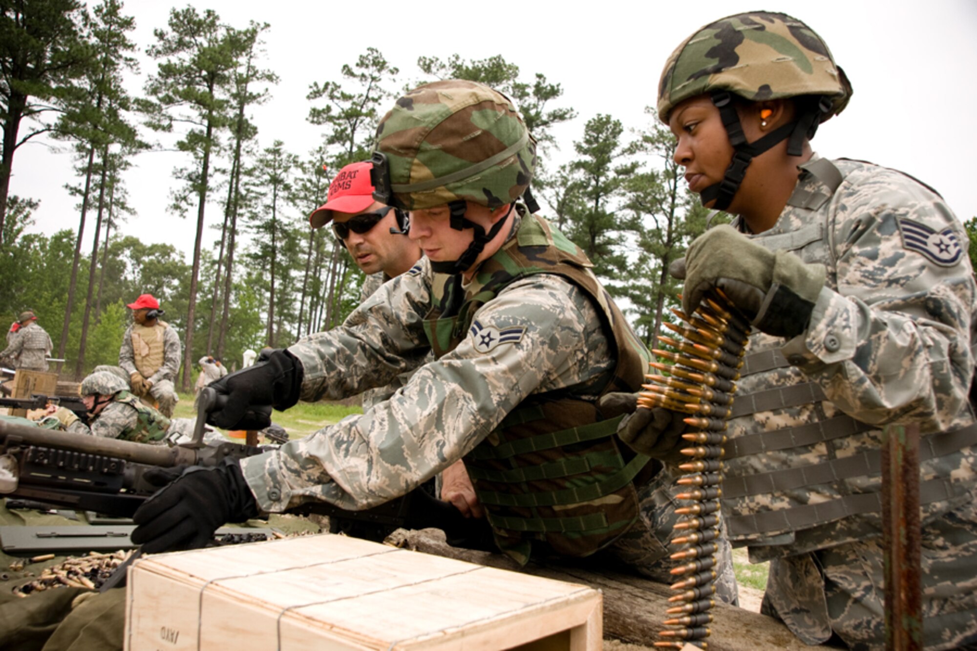 Staff Sgt. Matthew Chase supervises a barrel change performed by Airman First Class Ken Spaulding while Staff Sgt. Lela Gerrins prepares a belt of 7.62mm ammunition.  Each year, members of the 459th Security Forces Squadron are required to fire 1,100 rounds from both the M240 and M249. (U.S. Air Force Photo/ Capt. Nick Strocchia)  
