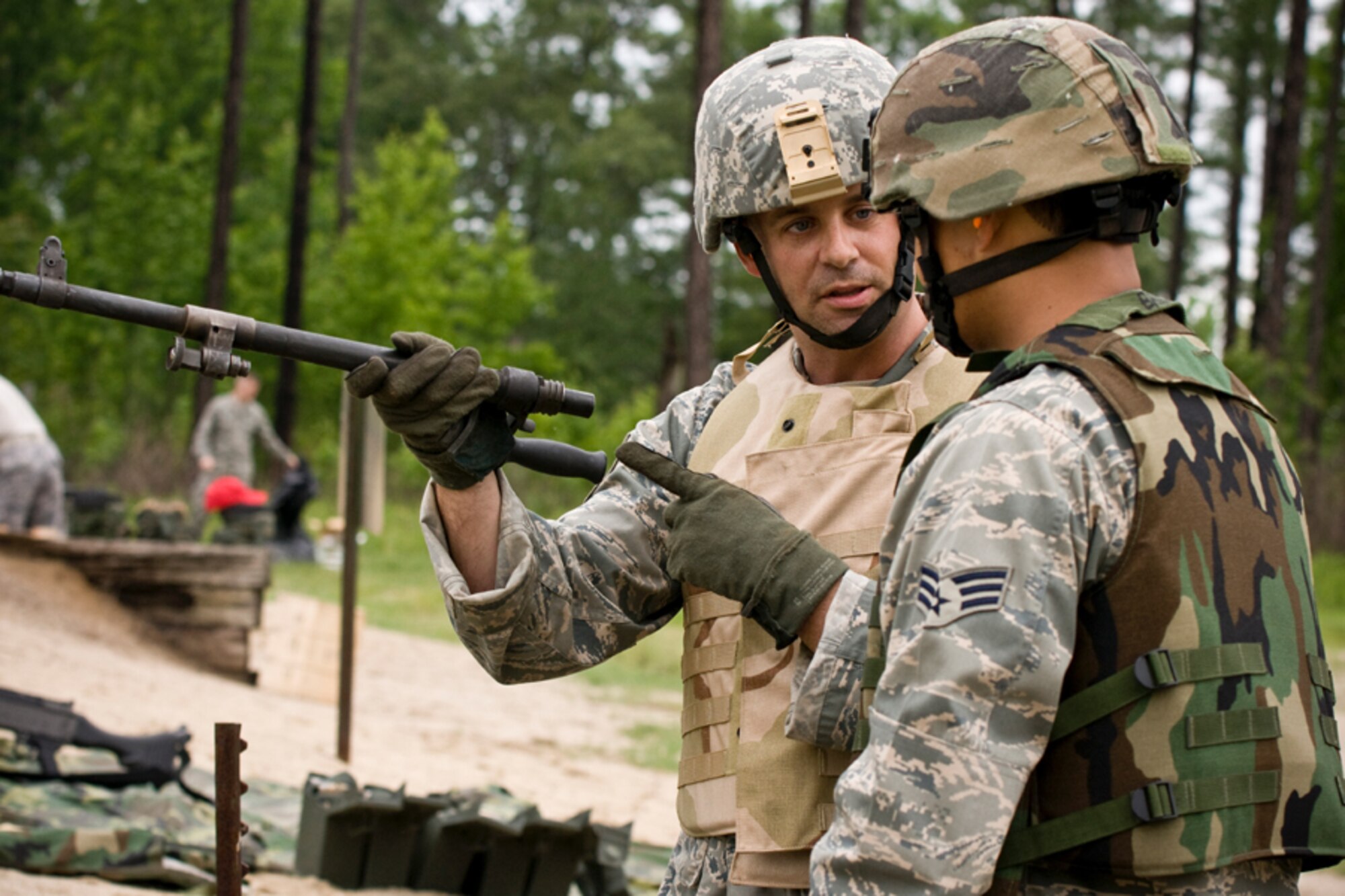 Staff Sgt. Matthew Chase explains the M240 barrel changing procedures to Senior Airman Edmund Santos.  The M240 requires frequent barrel changes with approximately every 200 rounds of ammunition during continuous high rates of fire. (U.S. Air Force Photo/ Capt. Nick Strocchia)
