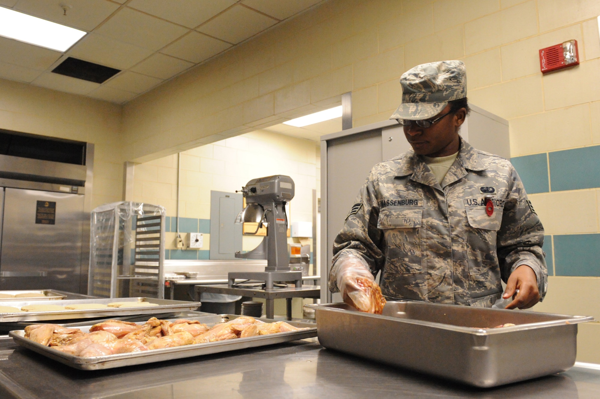 Senior Airman Ada Massenburg, 4th Force Support Squadron services apprentice, marinades chicken at the Southern Eagle Dining Facility on Seymour Johnson Air Force Base, N.C., June 16, 2009. Airman Massenburg received training in restaurant, hotel, and fitness management. (U.S. Air Force photo by Airman 1st Class Whitney S. Lambert)