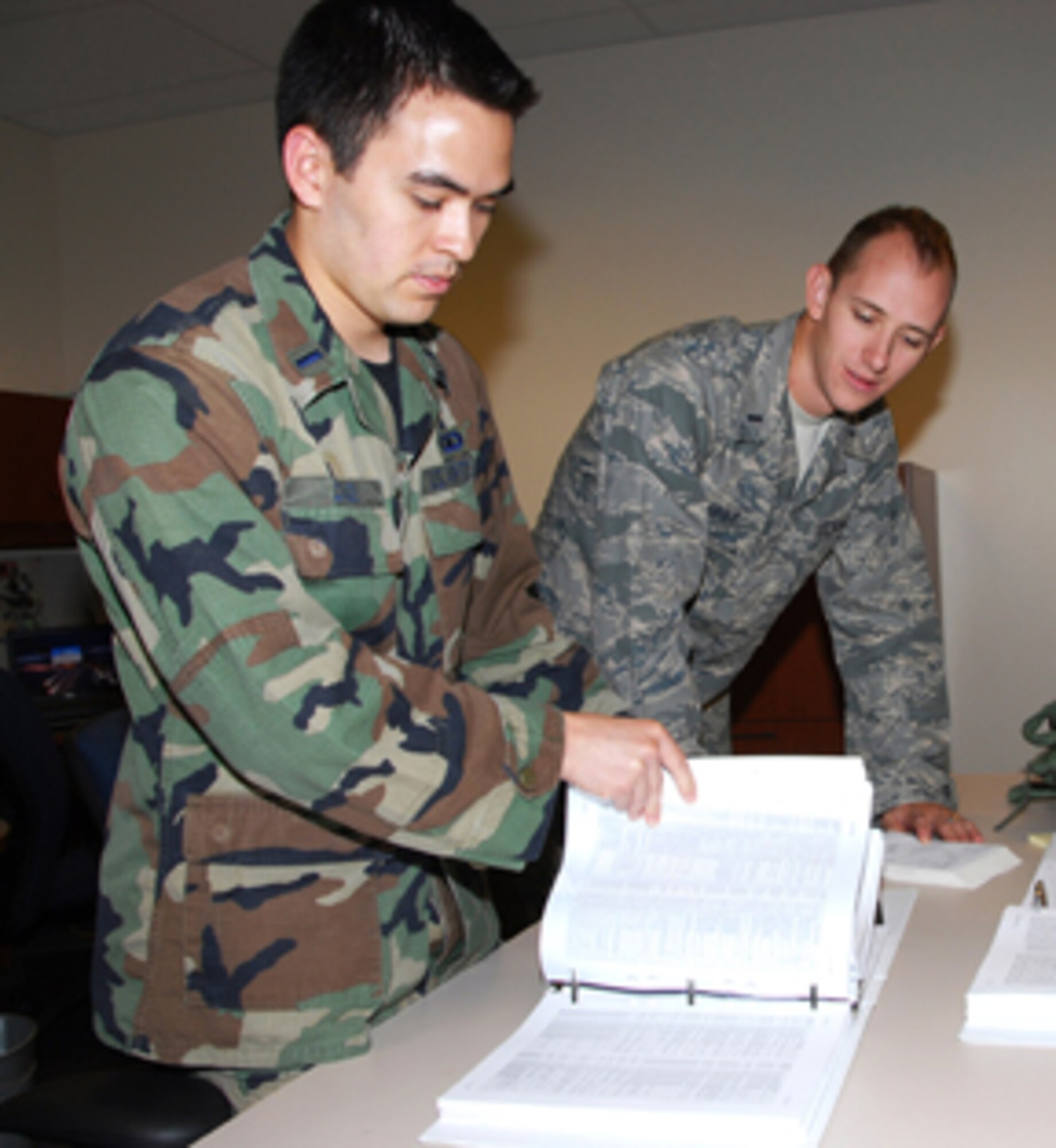 1st Lts. Sean Conley (left) and Charles Chapot, active duty airfield operation officer trainees, assigned to the 241st Air Traffic Control Squadron, look over air traffic controller manuals at the 241st ATCS. (U.S. Air Force photo by Staff Sgt. Michael Crane) 
