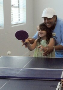 Lisa Mathieu, a youth center counselor, shows Cody Parther the finer points of ping-pong on June 16. The 12th Mission Support Squadron and 12th Services Division are merging June 26 to form the new 12th Force Support Squadron. (U.S. Air Force photo by Don Lindsey)