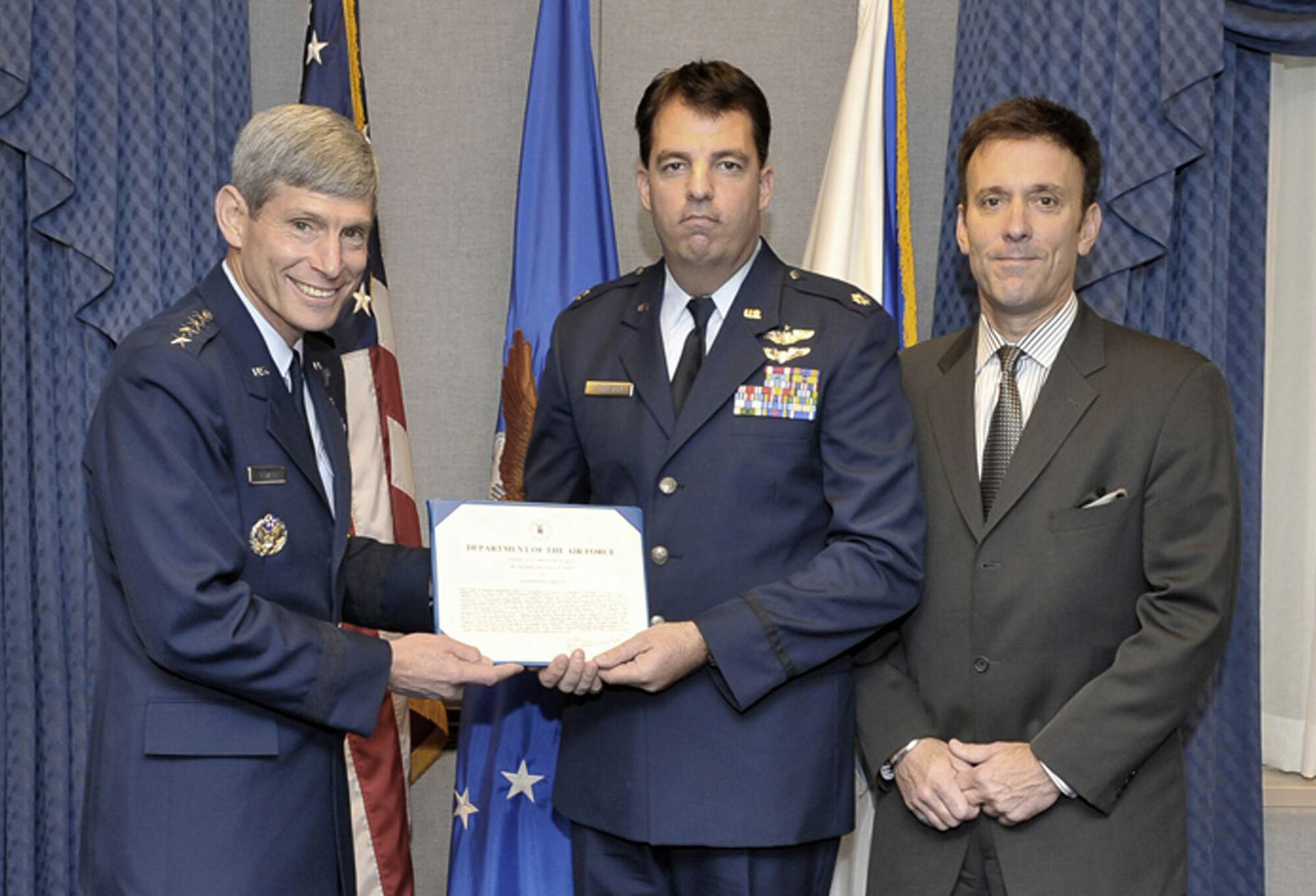 Air Force Chief of Staff Gen. Norton Schwartz assisted by Koren Kolligan presents Lt. Col. Booth M. Johnston with the Koren Kolligian Jr. Safety Award June 16. He received the award for an October 2007 incident in which he suffered a severe back and neck injury during a high-G maneuver. Despite the near total loss of use and lack of sensation in his hands and feet, Colonel Johnston was eventually able to level the aircraft and land at Ellington Field, Texas. (U.S. Air Force photo/Michael Pausic)