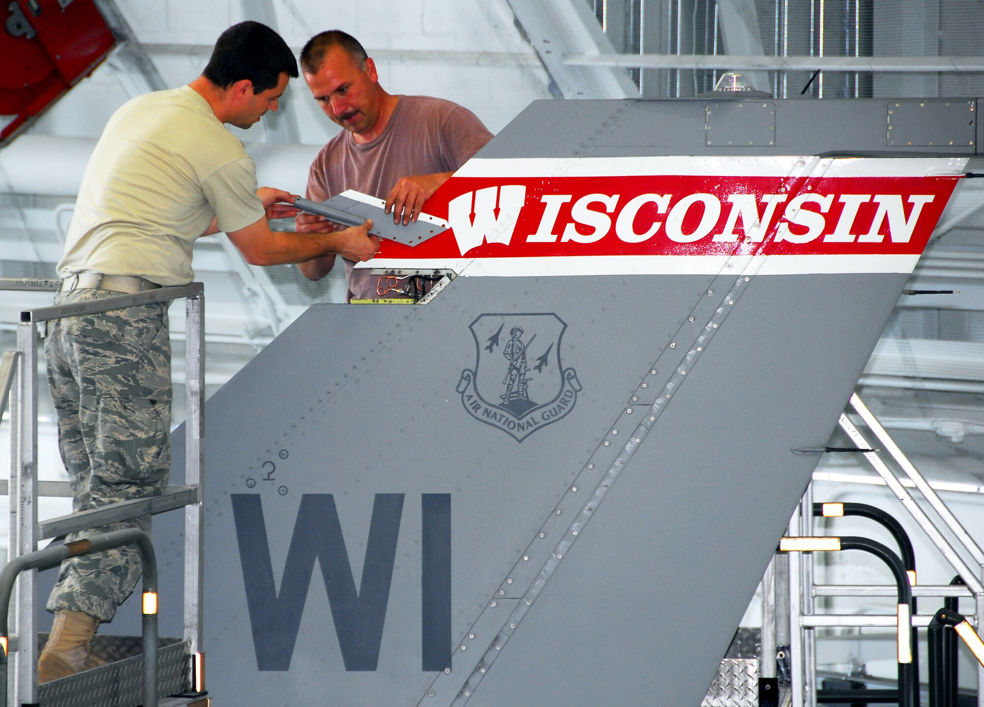 Tech. Sgt. Jeremy Wrolstad and Master Sgt. Todd Brueggeman, 115th Maintenance Squadron, repair a very-high frequency radio antenna on a F-16C Fighting Falcon May 27 in Bldg 400. The VHF radios are used as the pilot's auxiliary communications tool and the repair is done, on average, once a year per aircraft. (Photo by Tech. Sgt. Jon LaDue)