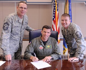 LANGLEY AIR FORCE BASE Va. -- Col. Matthew H. Molloy, 1st Fighter Wing commander, is accompanied by Chief Master Sergeant Kevin Slater, 1st Fighter Wing command Chief Master Sergeant and Master Sergeant Robert Casagrande, Air Force Sergeants Association Chapter 358 President, as he becomes a member of the AFSA here 17 June. (U.S. Air Force photo/Airman 1st Class Jonathan Koob) 