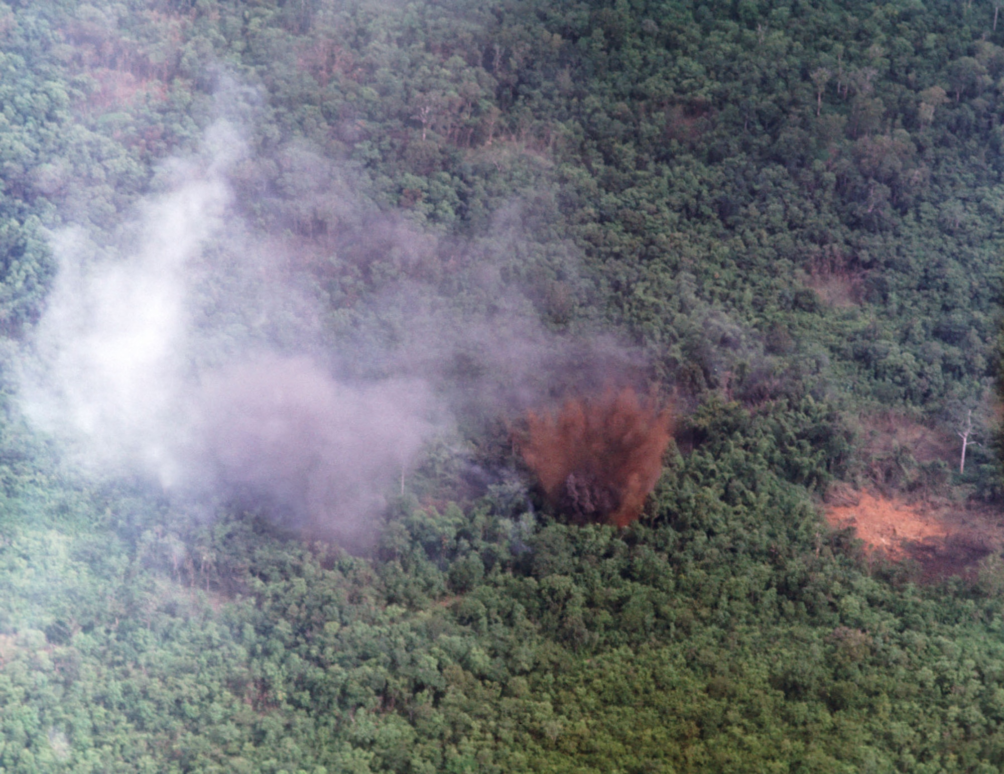 The impact of a 500 lb. bomb dropped by Yellow Jacket 11. Battle damage assessment (BDA) afterward indicated that the air strike killed 12 enemy soldiers, destroyed 44 bunkers and uncovered 3 tons of rice and 5 bunkers. (U.S. Air Force photo)