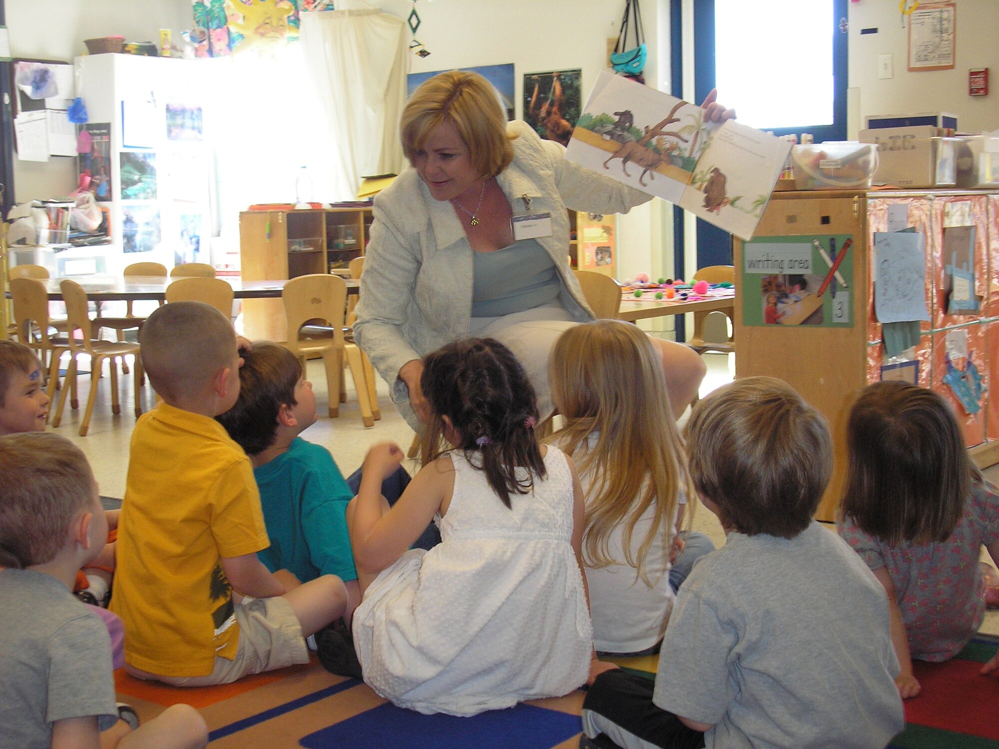 Sharon Burg,a wife of Twentieth Air Force Commander Maj. Gen. Roger W. Burg, reads a book May 27 to children in the child development center's classroom 108 during her and her husband's visit to the 90th Missile Wing. "The visit focused on our historic,cultural, environmental and energy aspects of the base, which by and large are unique in the Air Force," said Col. Mike Morgan,90th MW commander."General Burg said he was very impressed with the base." (Courtesy Photo) 