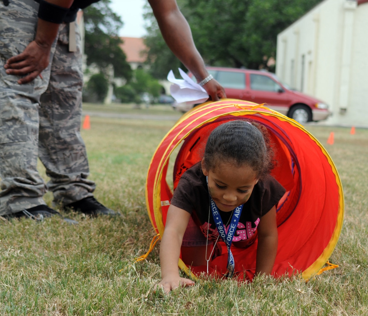 Monique Joseph navigates the obstacle course during the Airman and Family Readiness Flight's Operation Families Learning About Global Support, or FLAGS, event June 12. Operation FLAGS is a simulated deployment experience for family members to learn what their mom, dad, husband or wife goes through while preparing to deploy. (U.S. Air Force photo by Don Lindsey)