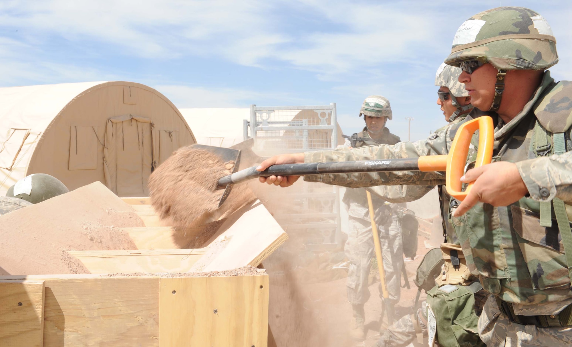 Members of team Holloman put together sand bags during the Phase II operational readiness exercise at the Civil Engineer pit, June 16, at Holloman Air Force Base, N.M. The sand bags are being used for added protection around the tents. (U.S. Air Force photo by Senior Airman Rachel Kocin)