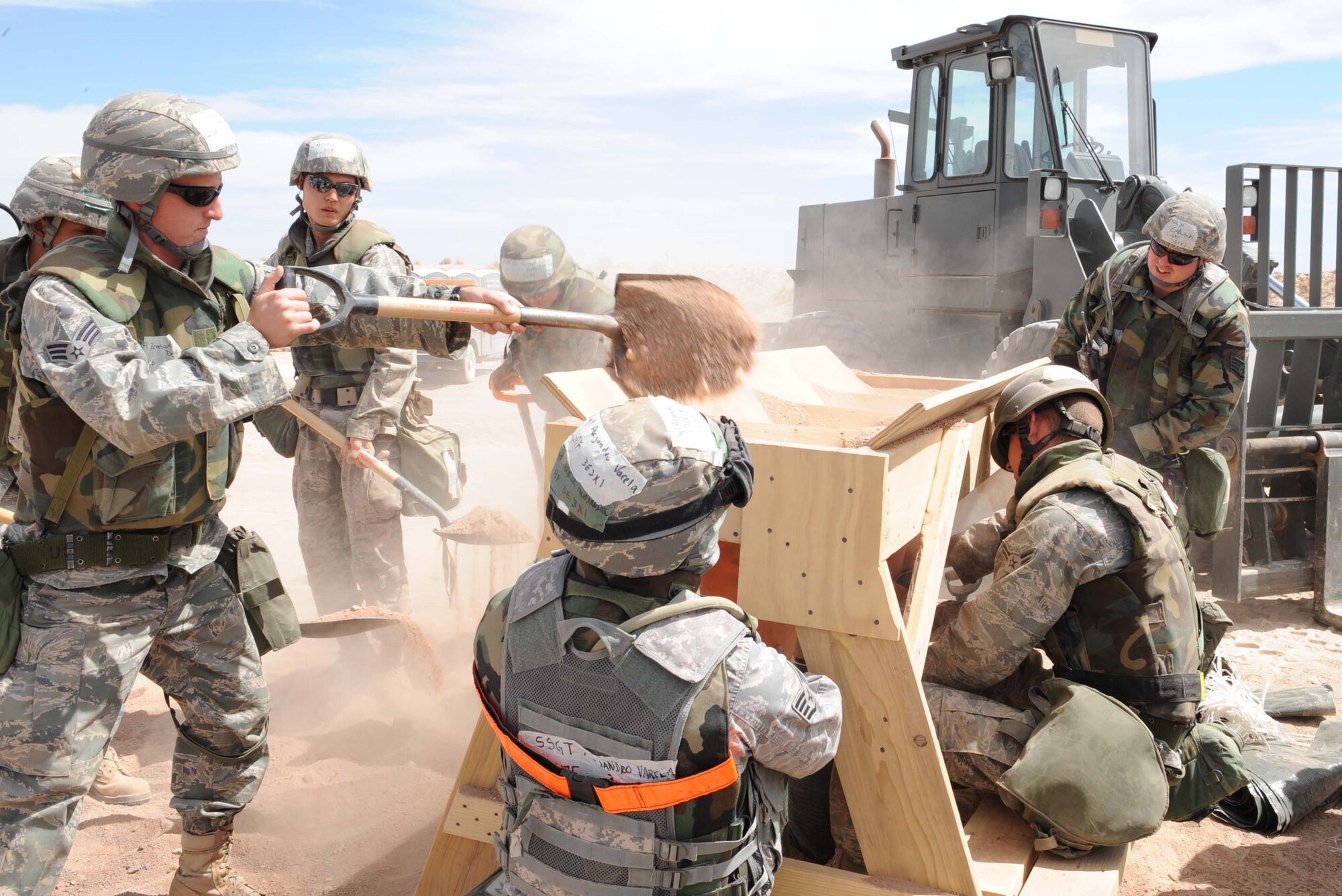 Members of team Holloman put together sand bags during the Phase II operational readiness exercise at the Civil Engineer pit, June 16, at Holloman Air Force Base, N.M. The sand bags are being used for added protection around the tents. (U.S. Air Force photo by Senior Airman Rachel Kocin)