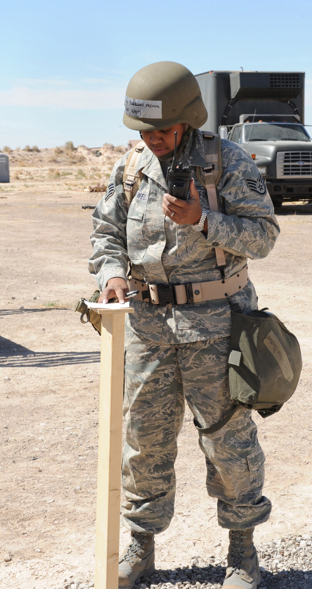 Staff Sgt. Felicia Blackwell, 49th Medical Support Squadron, checks the M-8 paper on a chemical stand to check for any contamination after a simulated aircraft attack at the civil engineer pit during the Phase II exercise at Holloman Air Force Base, N.M. Sergeant Blackwell was part of a two-person post-attack reconnaissance team. (U.S. Air Force photo/Airman 1st Class Sondra M. Escutia)