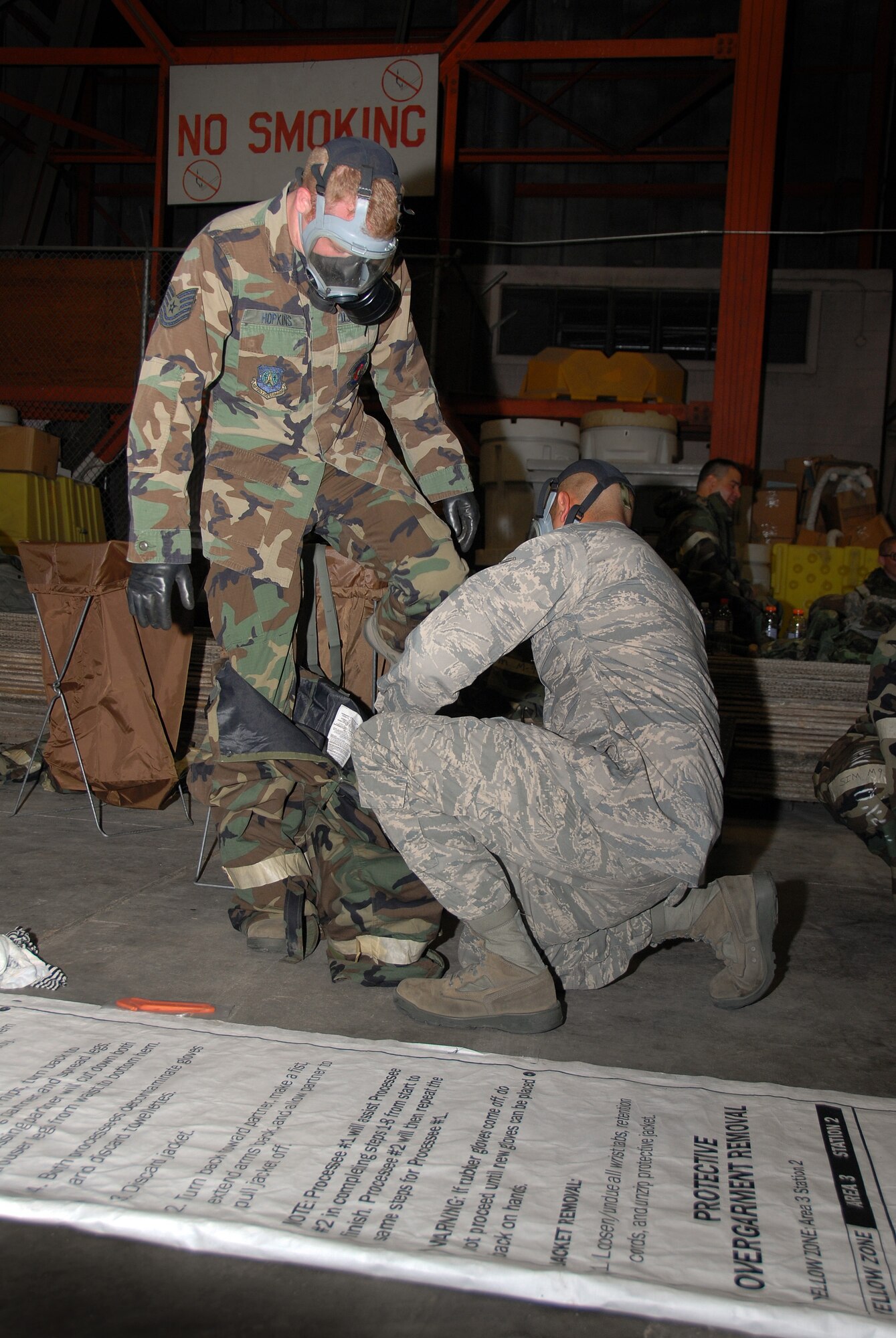 Two members of the 137th Space Warning Squadron remove outer protective garments during their annual Chemical, Biological, Radiological, Nuclear & Explosives (CBRNE) training June 10, 2009, Ellsworth Air Force Base, South Dakota.  Members of the 137th SWS located in Greeley Colorado, are participating in several training events to include CBRNE while at Ellsworth AFB this week to further enhance their one of a kind worldwide capable mission as a missile warning , space launch and detection mobile unit. (U.S Air Force photo by: Tech. Sgt. Wolfram M. Stumpf/Released)