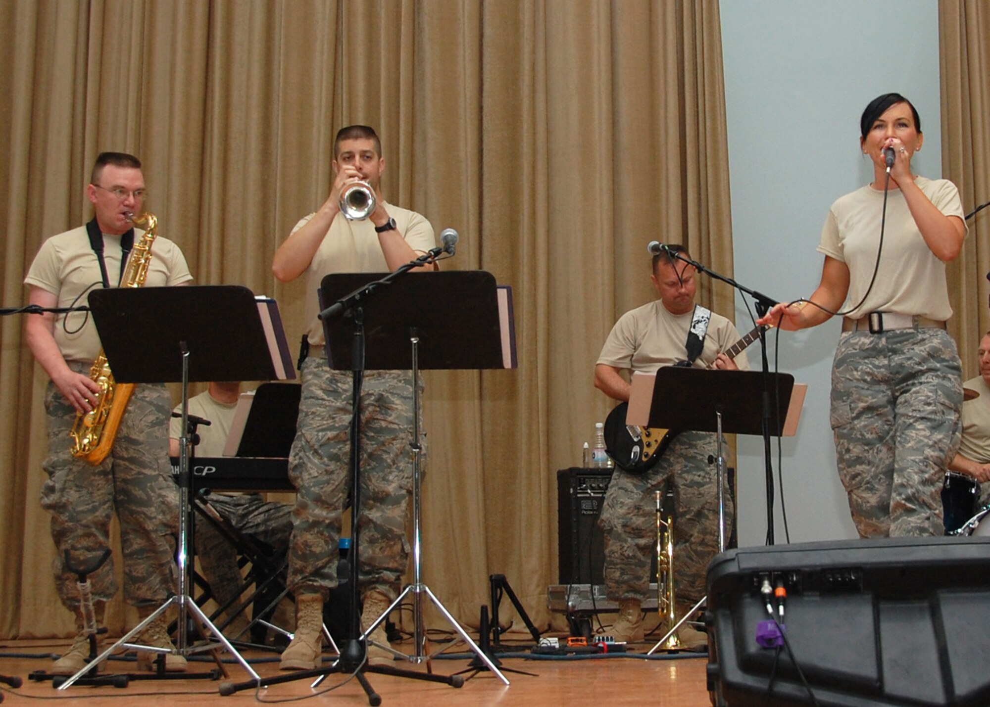 SOUTHWEST ASIA -- Airman 1st Class Johanna Brooks, Washington Air National Guard, steals the show as she sings her rendition of "Sweet Home Alabama" for Airmen depoyed to an air base in Southwest Asia, June 14. Airman Brooks along with other Airmen in the U.S. Air Force Central Expeditionary Band "Yuma" volunteered to come out to the Middle East from the Washington Air National Guard to perform for troop morale and community outreach concerts.(U.S. Air Force photo/Cadet First Class Gabriel Guzman)