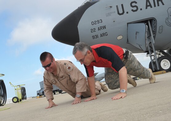 Jim Tressel, head football coach at Ohio State, gets Capt. Ronald "Rat" Ehresman to go along with a KC-135 boom operator-type pose for a photo. The change-it-up idea followed the countless photo requests Tressel and six other NCAA coaches graciously granted during Coaches Tour 2009, a morale-boosting mission that brought them to U.S. servicemembers. Captain Ehresman is a KC-135 Stratotanker pilot assigned to the 22nd Air Refueling Wing at McConnell Air Force Base, Kan. (U.S. Air Force photo/Tech. Sgt. Jason Schaap) 