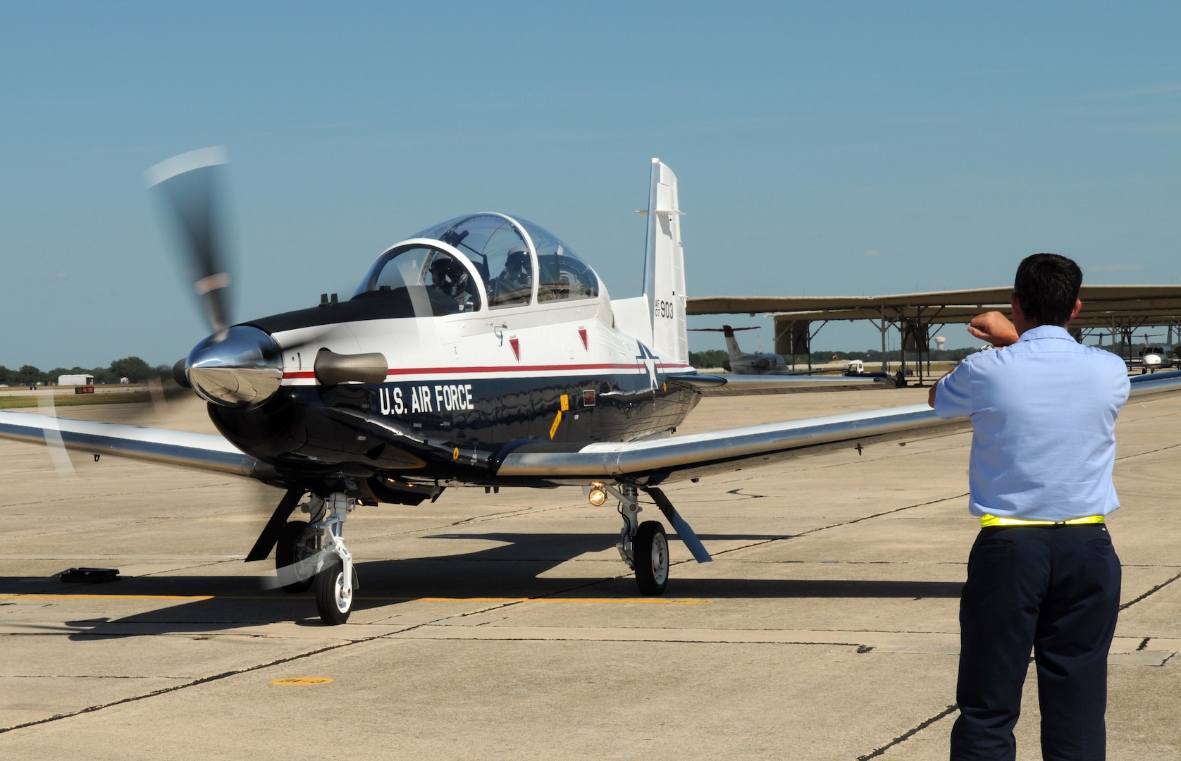 Delbert Dyer, 12th Maintenance Division, welcomes Brig. Gen. Richard Devereaux, Air Education and Training Command director of Intelligence, Operations and Nuclear Integration, into his parking space on the Randolph flightline June 16. General Deveraux delivered a new $4.2 million T-6 to the 12th Flying Training Wing fleet. (U.S. Air Force photo by Rich McFadden)