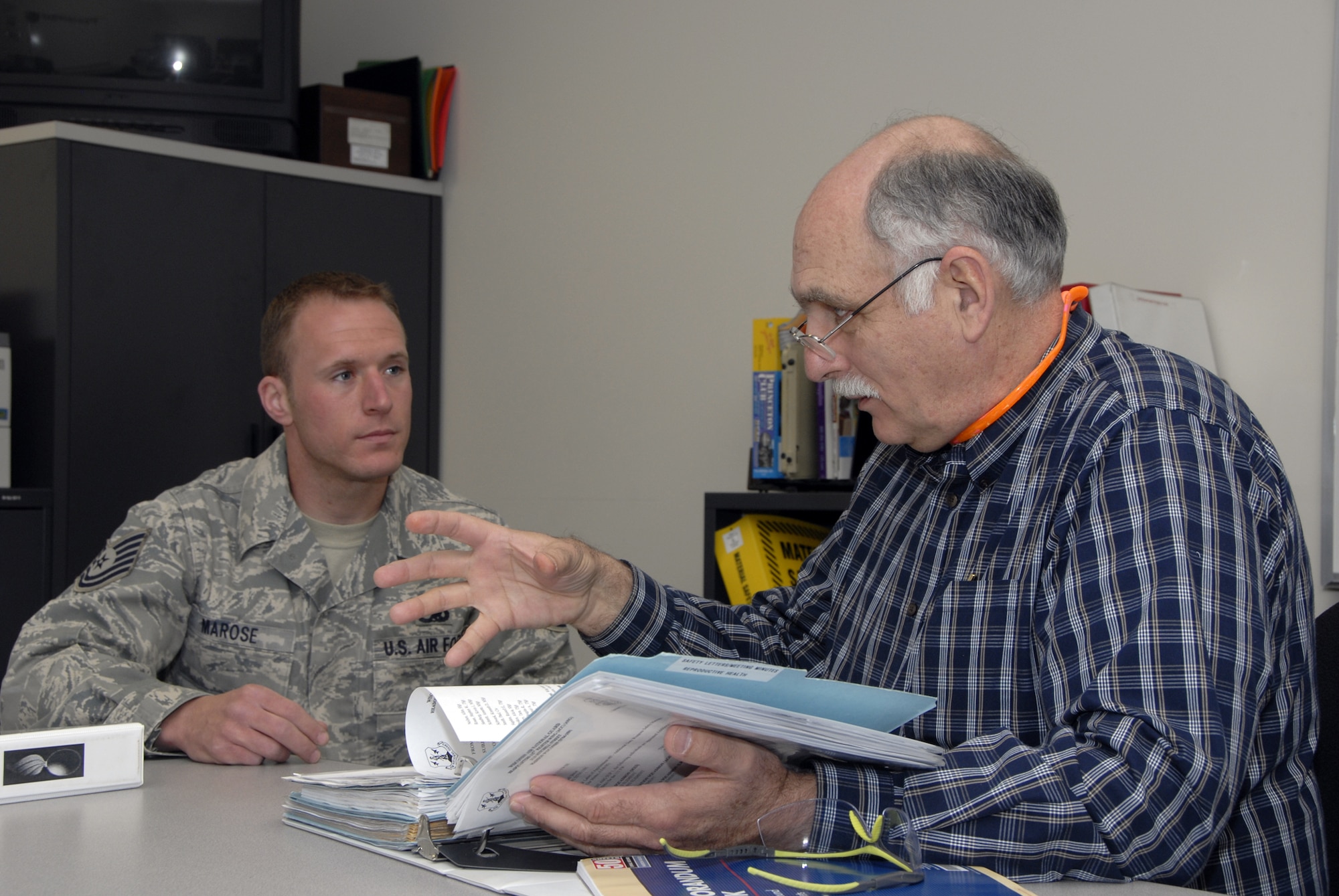 Nick Antonio, a Voluntary Protection Program inspector for the Occupational Safety and Health Administration, reviews paperwork with Tech. Sgt. Matt Marose, 115th Maintenance Squadron. Mr. Antonio was part of a four-person inspection team who evaluated Truax Field in areas of safety, training and hazardous waste management. Following the week-long inspection, the team announced they would be recommending the wing for the VPP-Star, which is OSHA's highest rating. (Photo by Master Sgt. Dan Richardson)