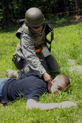 SHAW AIR FORCE BASE, S.C. -- Airman 1st Class Yesenia Fernandez, 20th Civil Engineer Squadron, checks Senior Airman Micah Blanton, 20th Component Maintenance Squadron, and opposing forces team member, for a pulse during Team Shaw's operational readiness inspection, June 15. The ORI will evaluate the training and preparedness of Shaw Airmen for homeland attack and worldwide deployment. (U.S. Air Force photo/Senior Airman Kathrine McDowell) 
