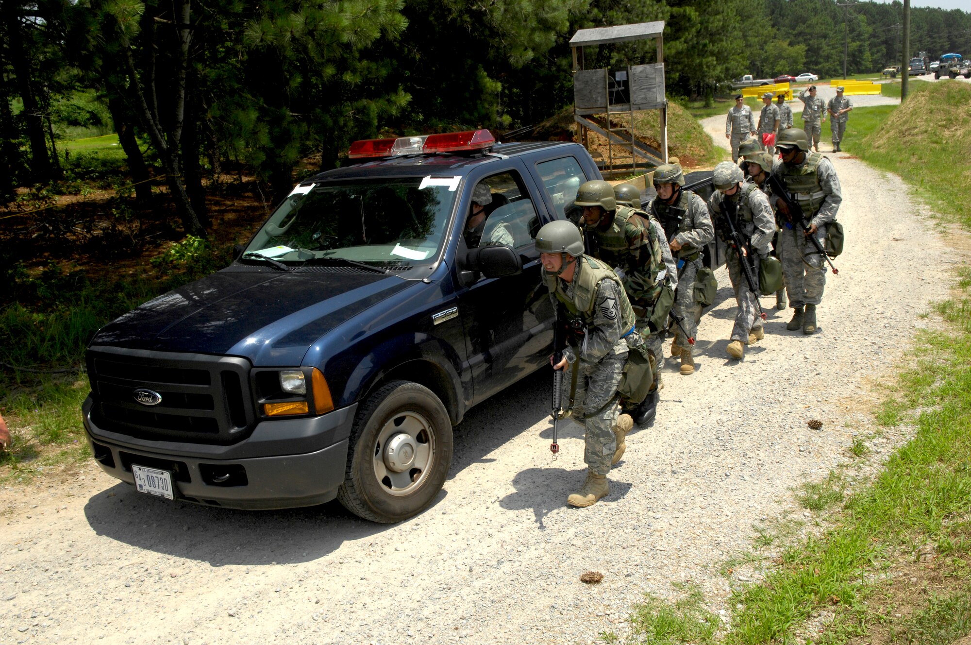 SHAW AIR FORCE BASE, S.C. -- Members of the 20th Civil Engineer Squadron take cover beside a moving vehicle as they approach a simulated unsecure area duringTeam Shaw's operational readiness inspection, June 15. The team will clear the area of opposing forces so a secure cantonment area can be set up. The ORI will evaluate the training and preparedness of Shaw's airmen for homeland attack and worldwide deployment. (U.S. Air Force photo/Senior Airman Kathrine McDowell)
