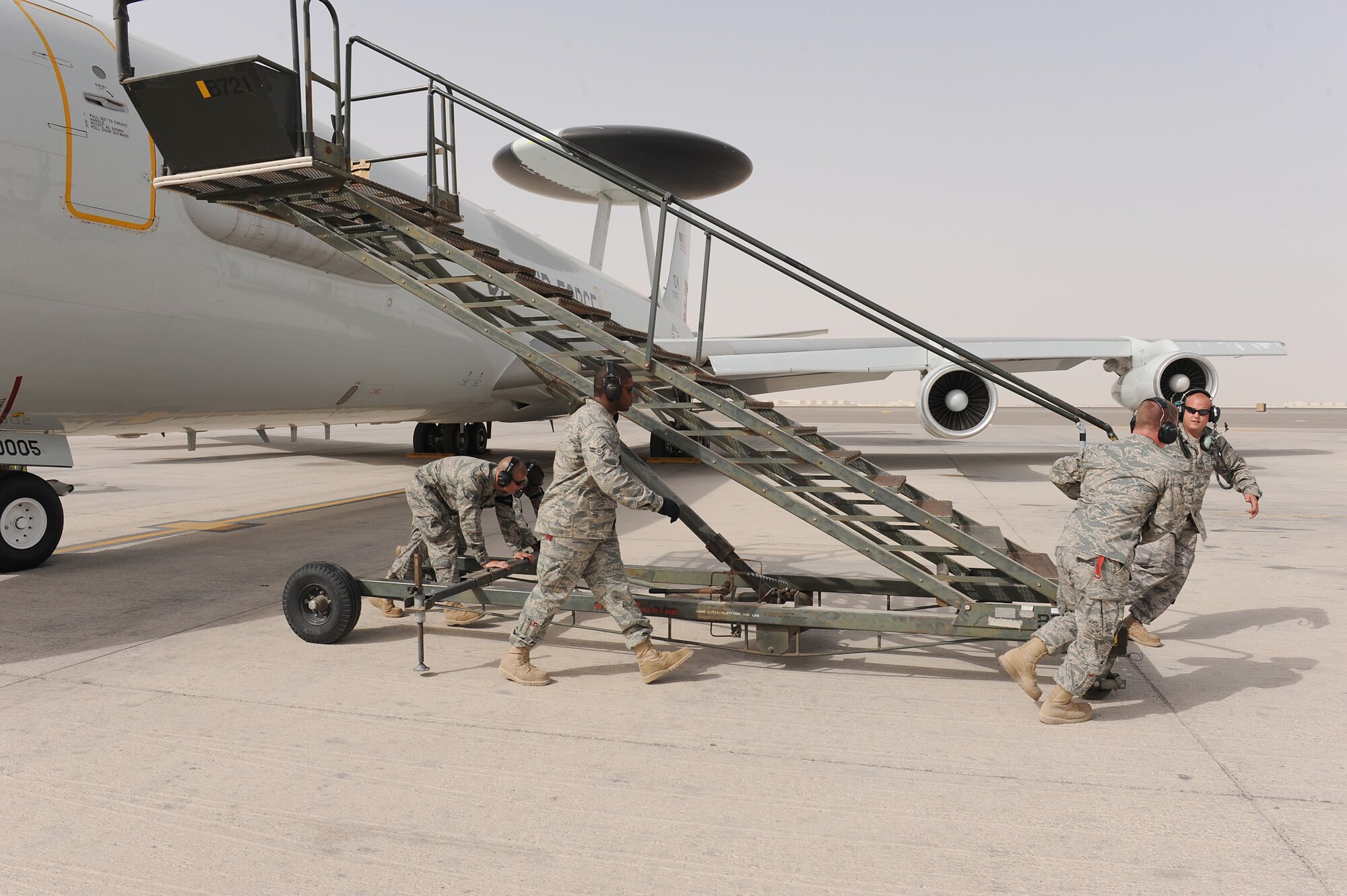SOUTHWEST ASIA - Maintainers from the 380th Expeditionary Aircraft Maintenance Squadron, Sentry Aircraft Maintenance Unit, pull a B-1 stand away from an E-3 Sentry prior to it's take-off, June 10 at an undisclosed location in Southwest Asia. The Sentry maintainers work around the clock performing maintenance, launching and recovering the aircraft, keeping it flying the tasking order every day. (U.S. Air Force photo by Senior Airman Brian J. Ellis) (Released)