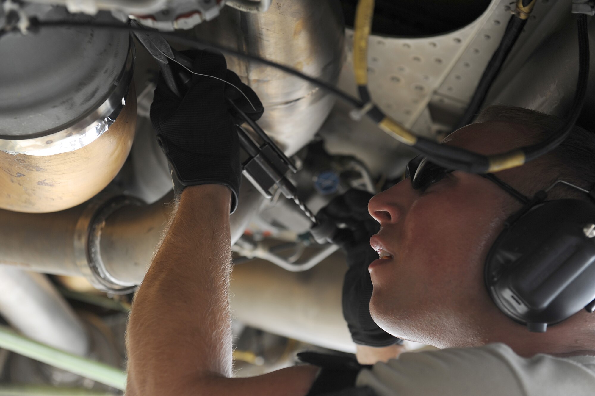 SOUTHWEST ASIA - Senior Airman Lance Carmichael, 380th Expeditionary Aircraft Maintenance Squadron, Sentry Aircraft Maintenance Unit, tightens a clamp to fix a bleed air leak an air conditioning system on an E-3 Sentry, June 10 at an undisclosed location in Southwest Asia. The Sentry maintainers work around the clock performing maintenance, launching and recovering the aircraft, keeping it flying the tasking order every day. (U.S. Air Force photo by Senior Airman Brian J. Ellis) (Released)