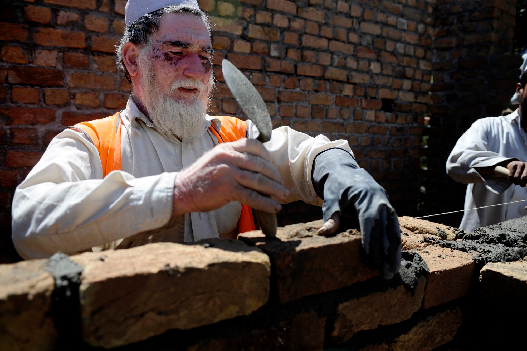 A local contractor spreads mortar for a development site May 30, 2009, in Nangarhar Province, Afghanistan. The development is monitored by the Nangarhar Provincial Reconstruction Team, Forward Operating Base Finley-Shields, Afghanistan.  The PRT is responsible for development and reconstruction projects in Nangarhar Province. The projects are built by local and contractors and are designed to improve the livelihood of the people living in the area. (U.S. Air Force Photo by Staff. Sgt. Shawn Weismiller)