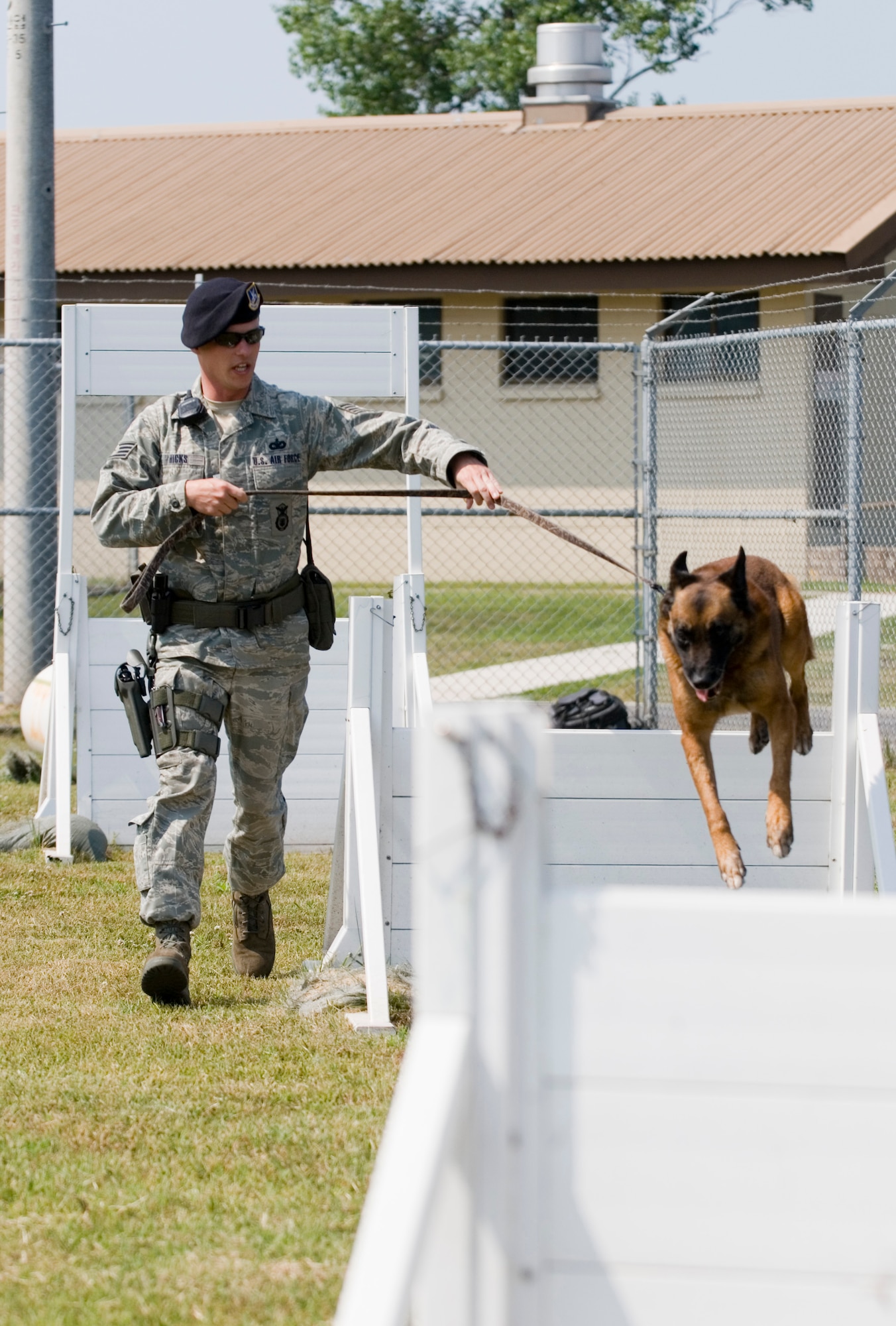 KUNSAN AIR BASE, Republic of Korea -- Staff Sgt. Joshua Hicks, 8th Security Forces Squadron, leads military working dog Rico through an obstacle course during obedience Training June 16. Sergeant Hicks originally from Sault Ste. Marie MI, works with Rico on his patrol and obedience training every morning prior to their patrol. (U.S. Air Force photo by Senior Airman Jonathan Steffen)