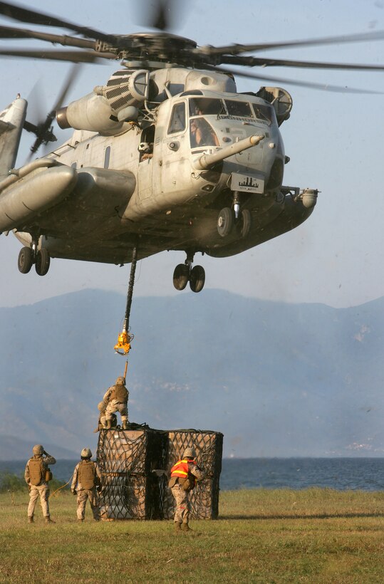 A CH-53E Super Stallion helicopter from Marine Medium Tiltrotor Squadron 263, Reinforced, 22nd Marine Expeditionary Unit, hovers above pallets of supplies while Marines attach the load for airlift in Greece, June 4, 2009. The Marines are assigned to Combat Logistics Battalion 22.