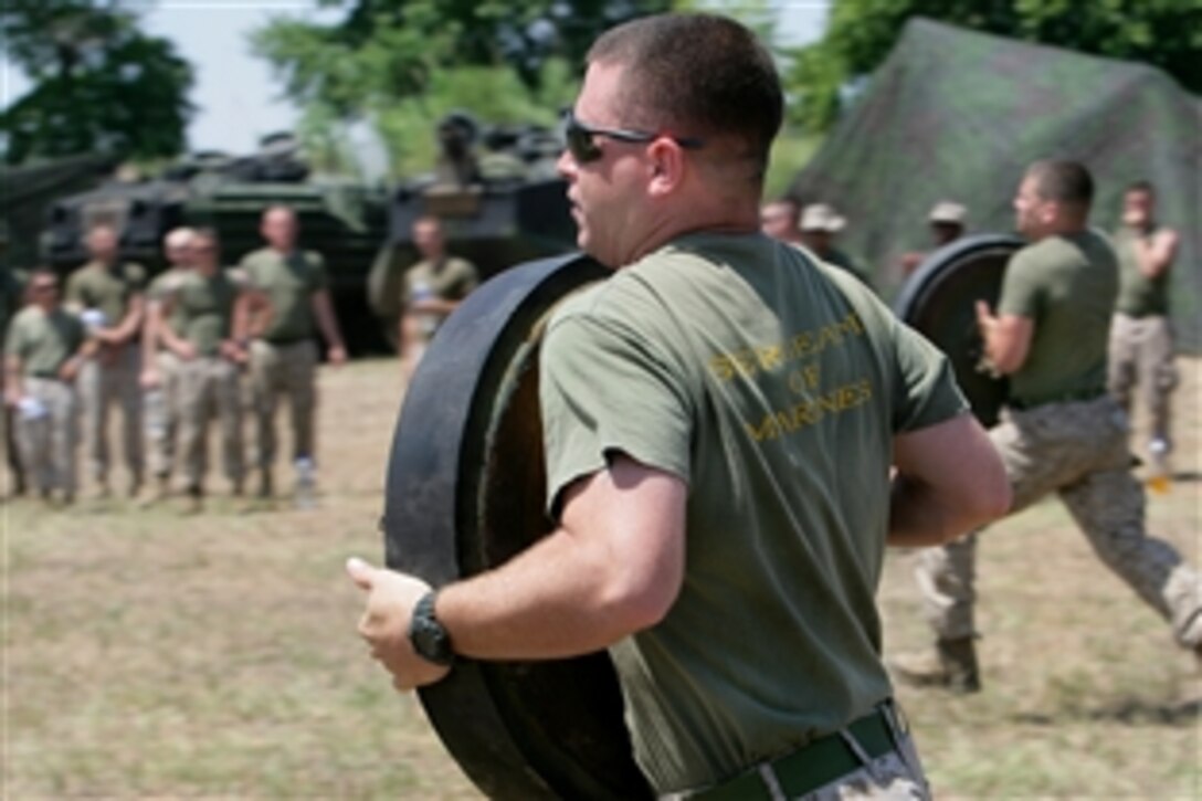 U.S. Marines and sailors participate in the road-wheel relay as part of the "Betio Greece Olympics" on Nea Anchialos Air Force Base, Greece, June 7, 2009. The Marines and sailors are assigned to Battalion Landing Team, 3rd Battalion, 2nd Marine Regiment, 22nd Marine Expeditionary Unit. The "Olympic" events are designed to boost morale before training begins.