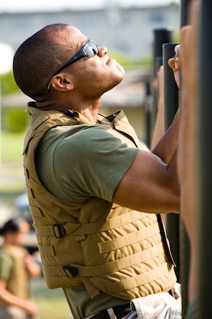 Staff Sgt. Dominique G. Laboy, Super PFT winner and enlisted head of the passenger section at the air terminal here, raises his chin to complete 17 pull-ups while wearing a flak jacket and combat utility uniform during the Super Physical Fitness Test put on by Headquarters and Headquarters Squadron June 17. Laboy was the overall winner of the competition, which consisted of a PFT, Combat Fitness Test, a run through an obstacle course and other physical feats in a two-hour timeframe.